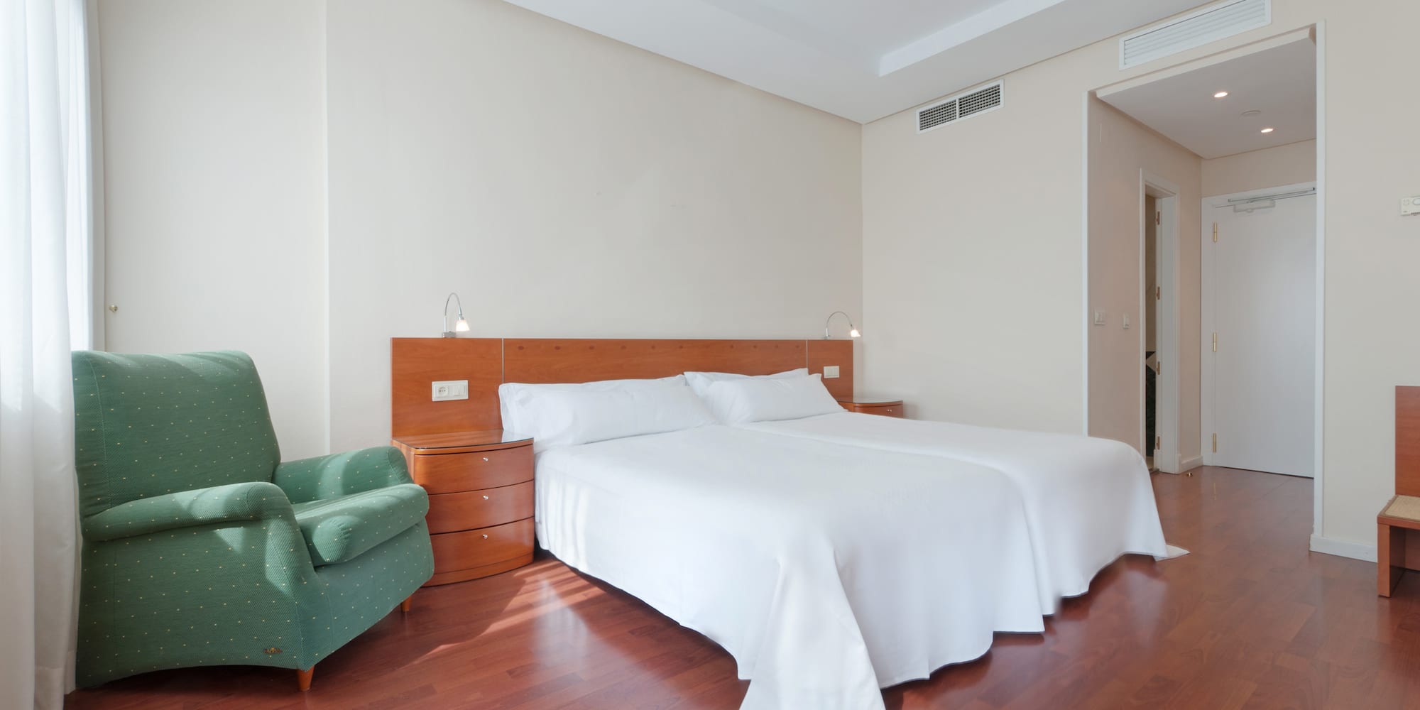 a room with a bed and a green chair