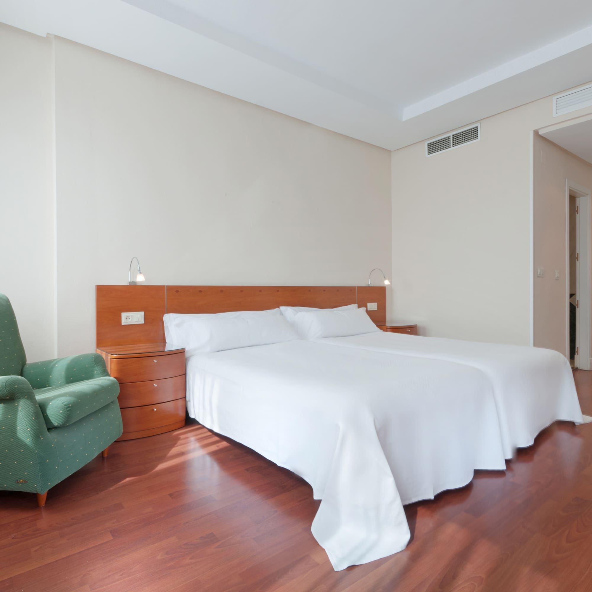 a room with a bed and a green chair