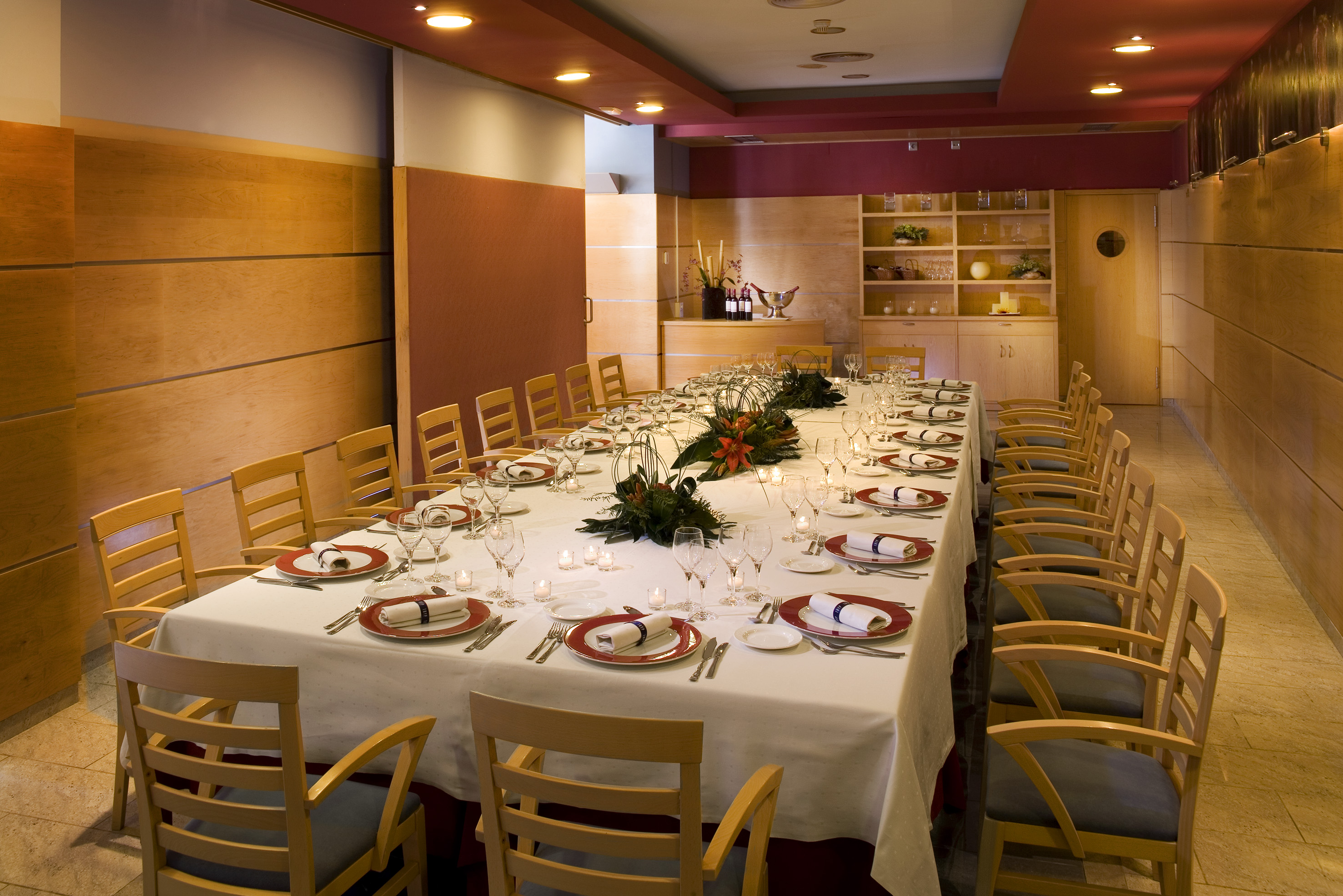 Formal dining table set with place settings, glasses, and floral centerpieces.