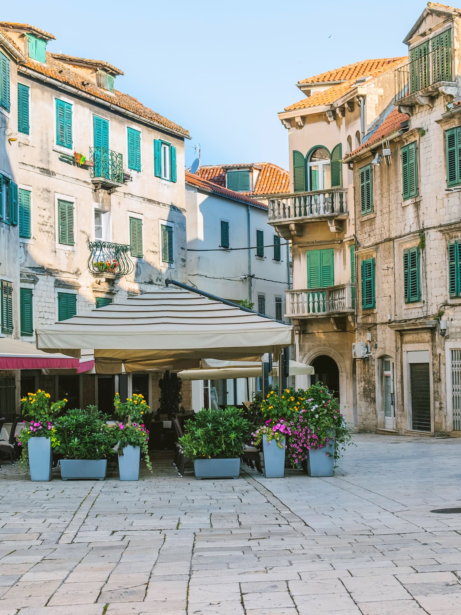 a courtyard with flowers and buildings