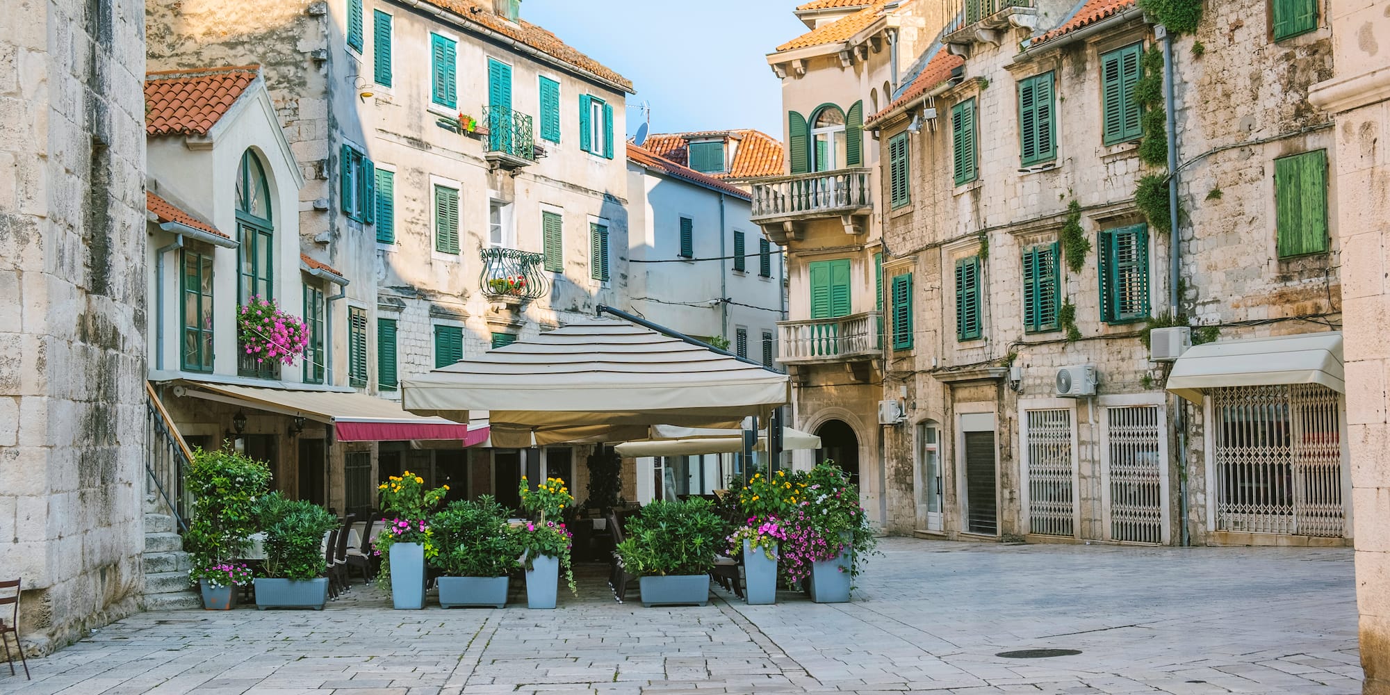 a courtyard with flowers and buildings