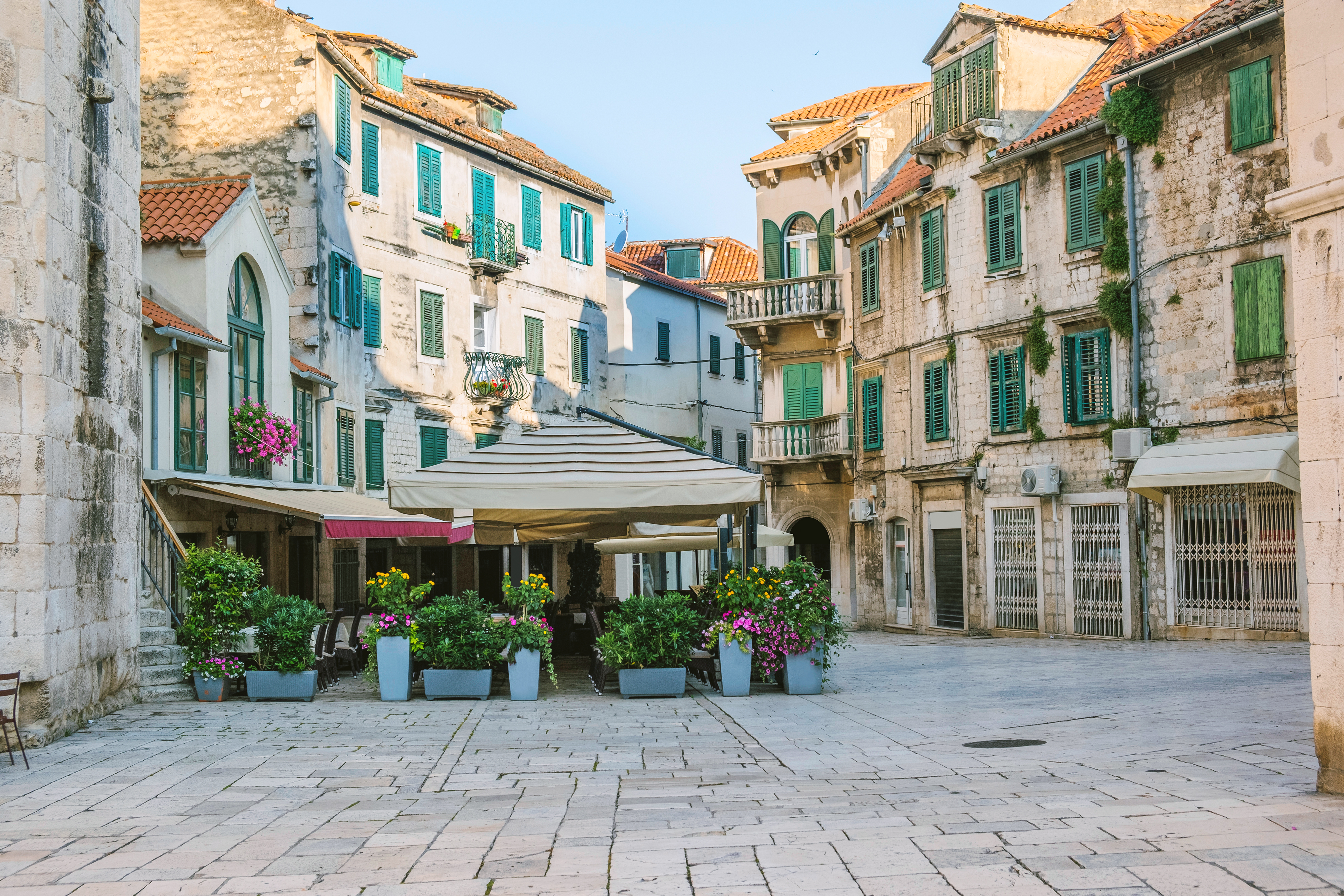 a courtyard with flowers and buildings