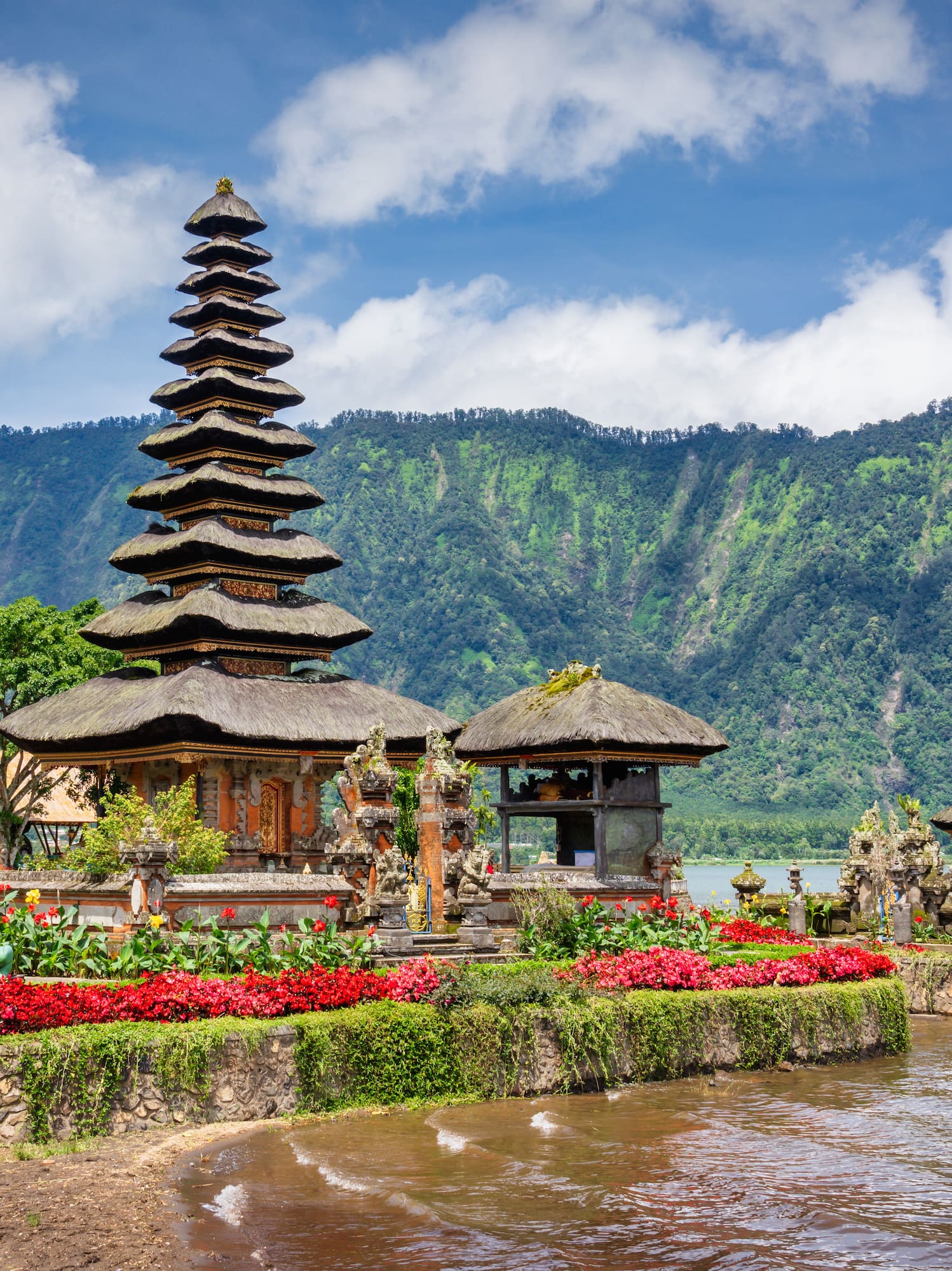 a lake with a pagoda and flowers