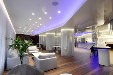 a room with white furniture and purple lighting