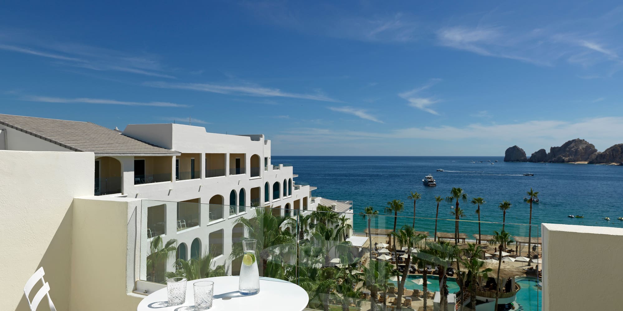 a table and chairs overlooking a beach and a body of water