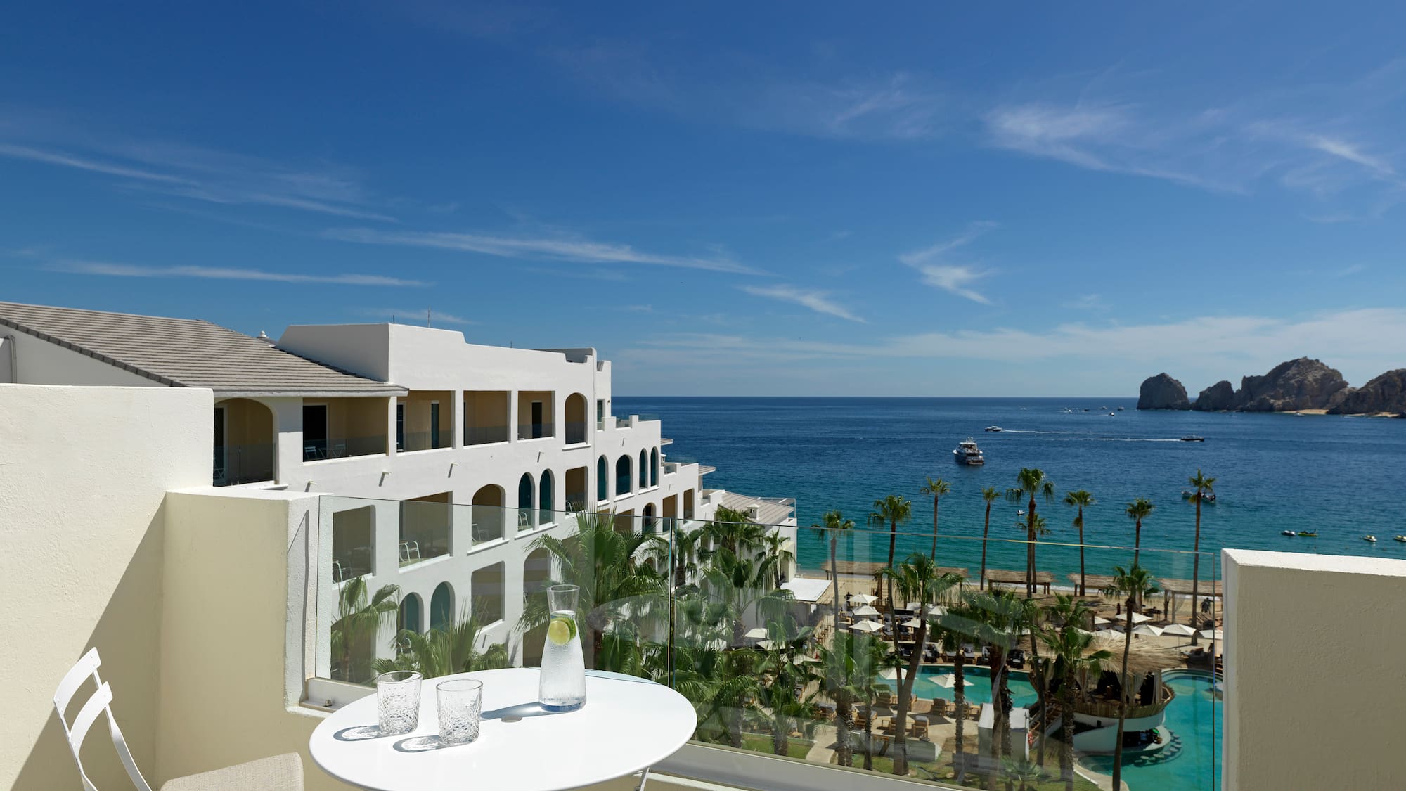 a table and chairs overlooking a beach and a body of water