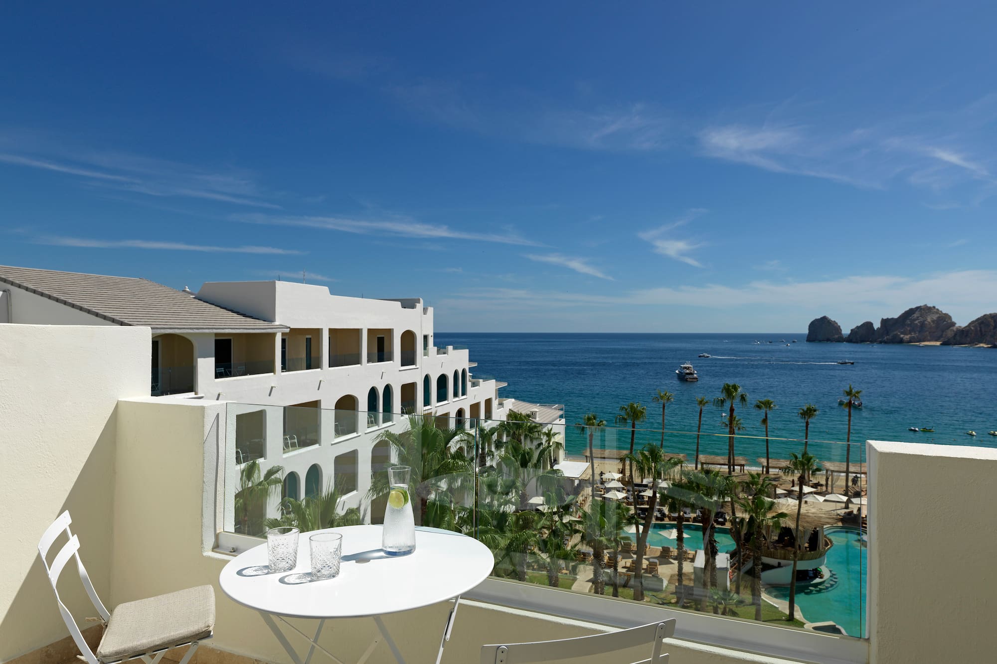 a table and chairs overlooking a beach and a body of water