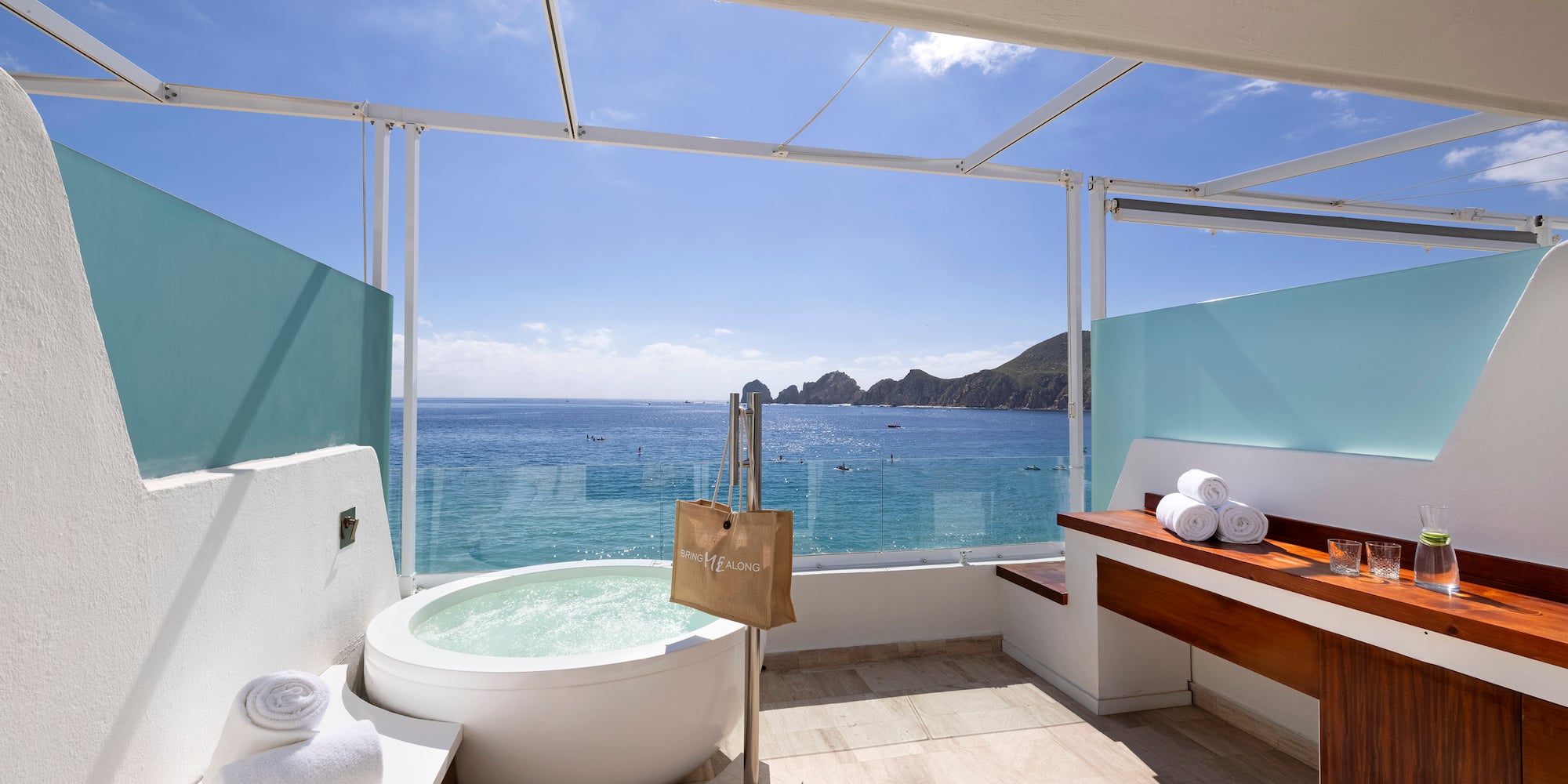 a bathroom with a tub and a large window overlooking the ocean