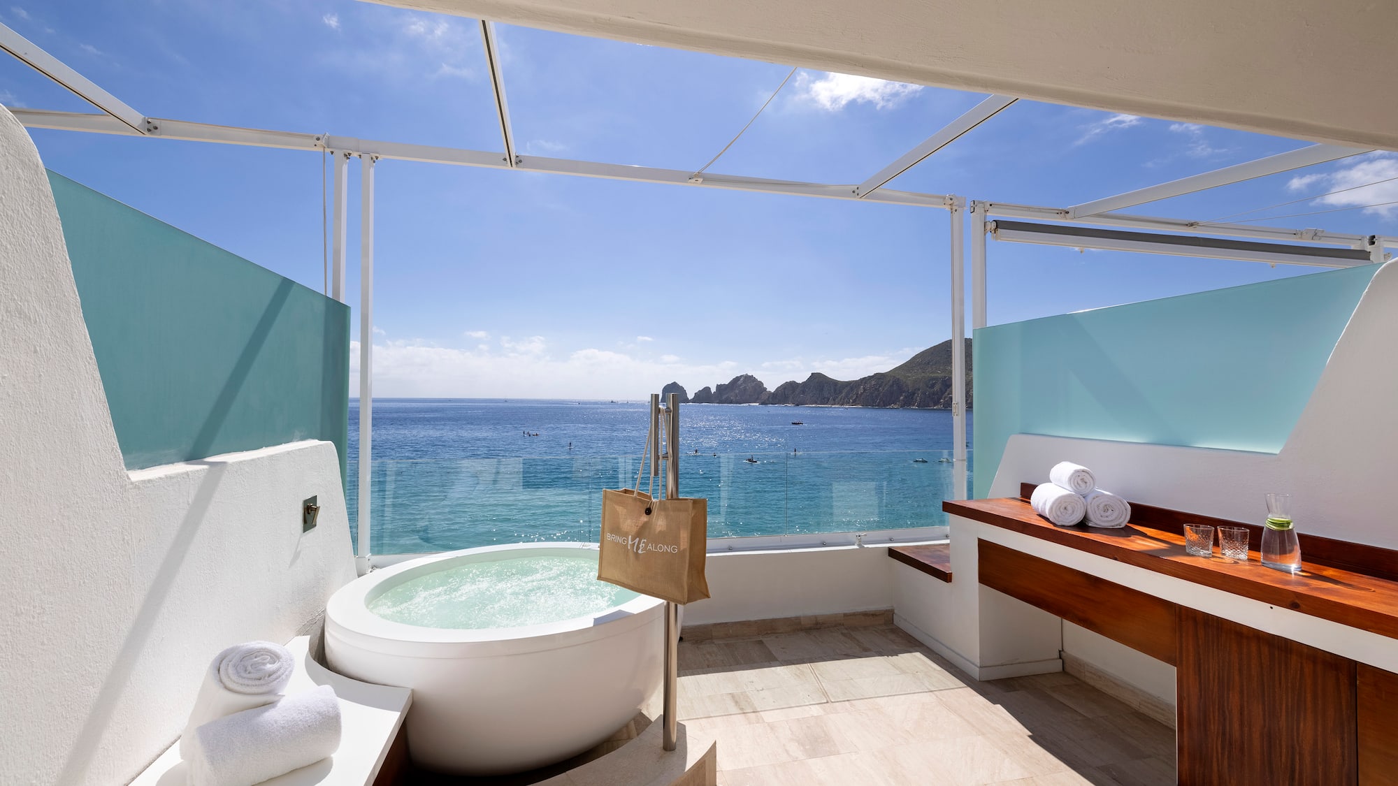 a bathroom with a tub and a large window overlooking the ocean