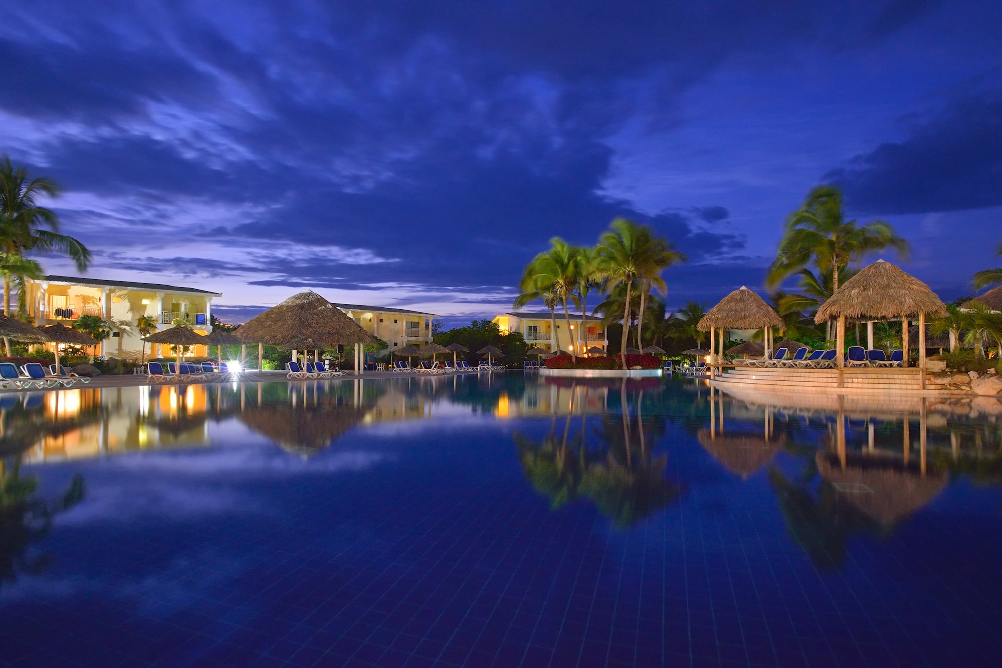 a pool with a building and palm trees