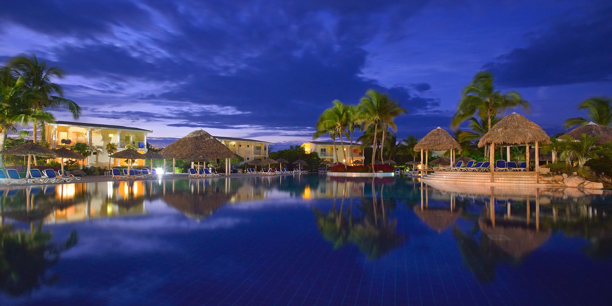 a pool with a building and palm trees