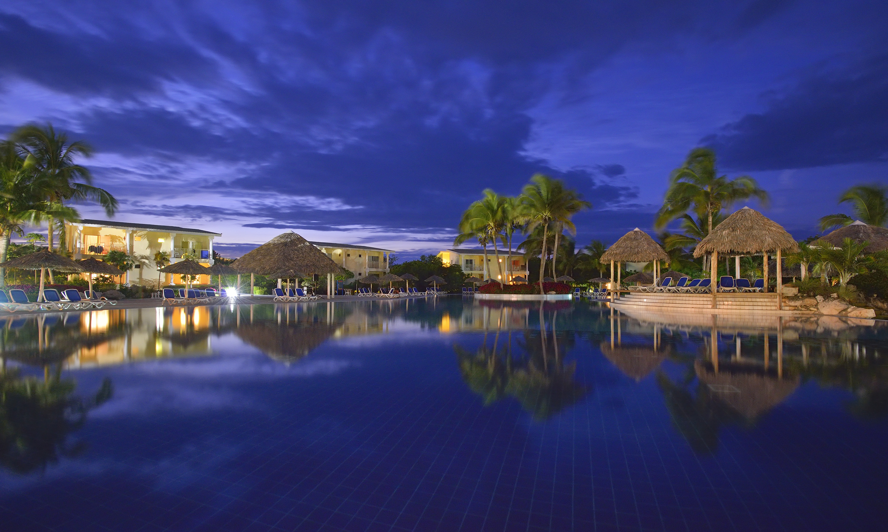 a pool with a building and palm trees