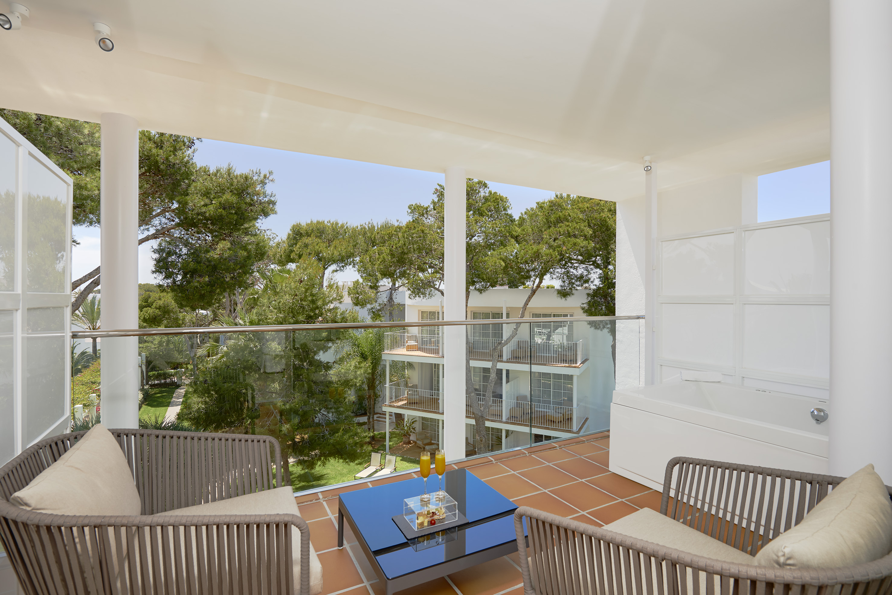 a balcony with a glass railing and chairs