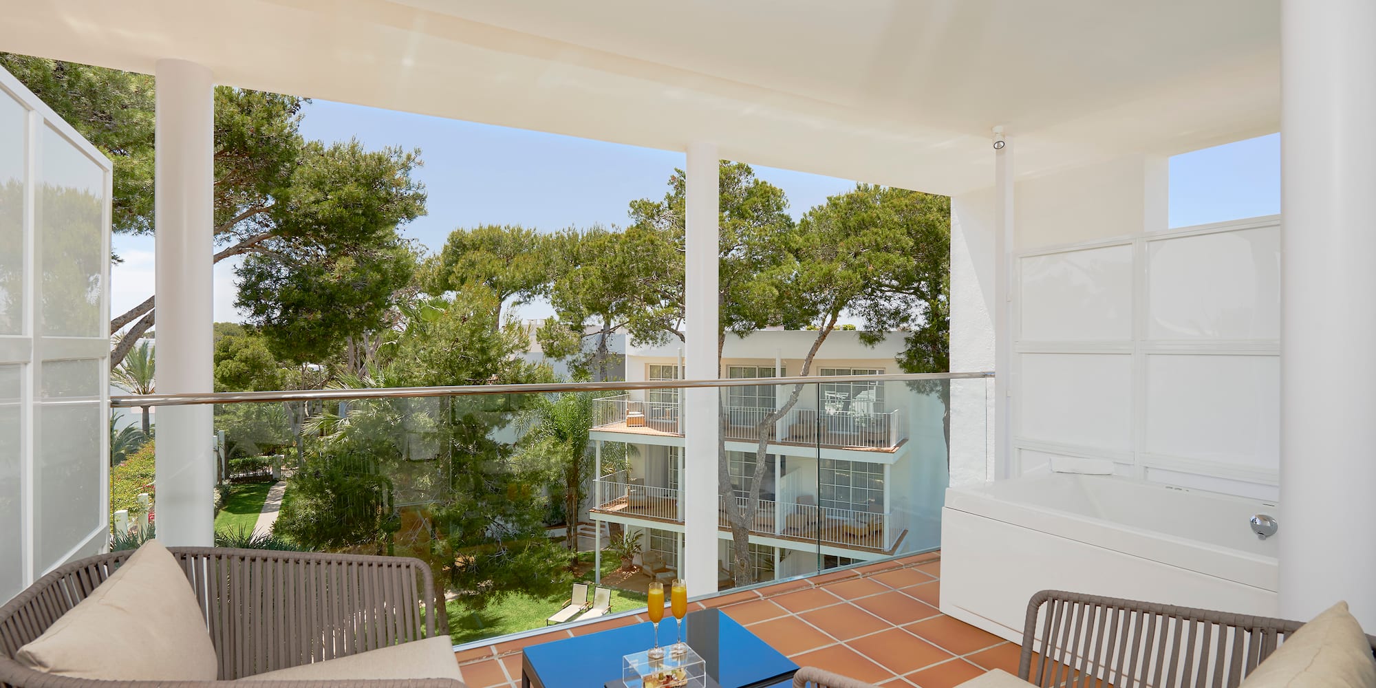 a balcony with a glass railing and chairs