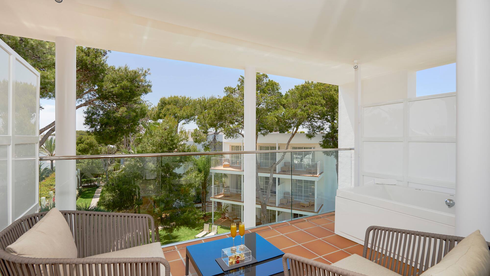 a balcony with a glass railing and chairs