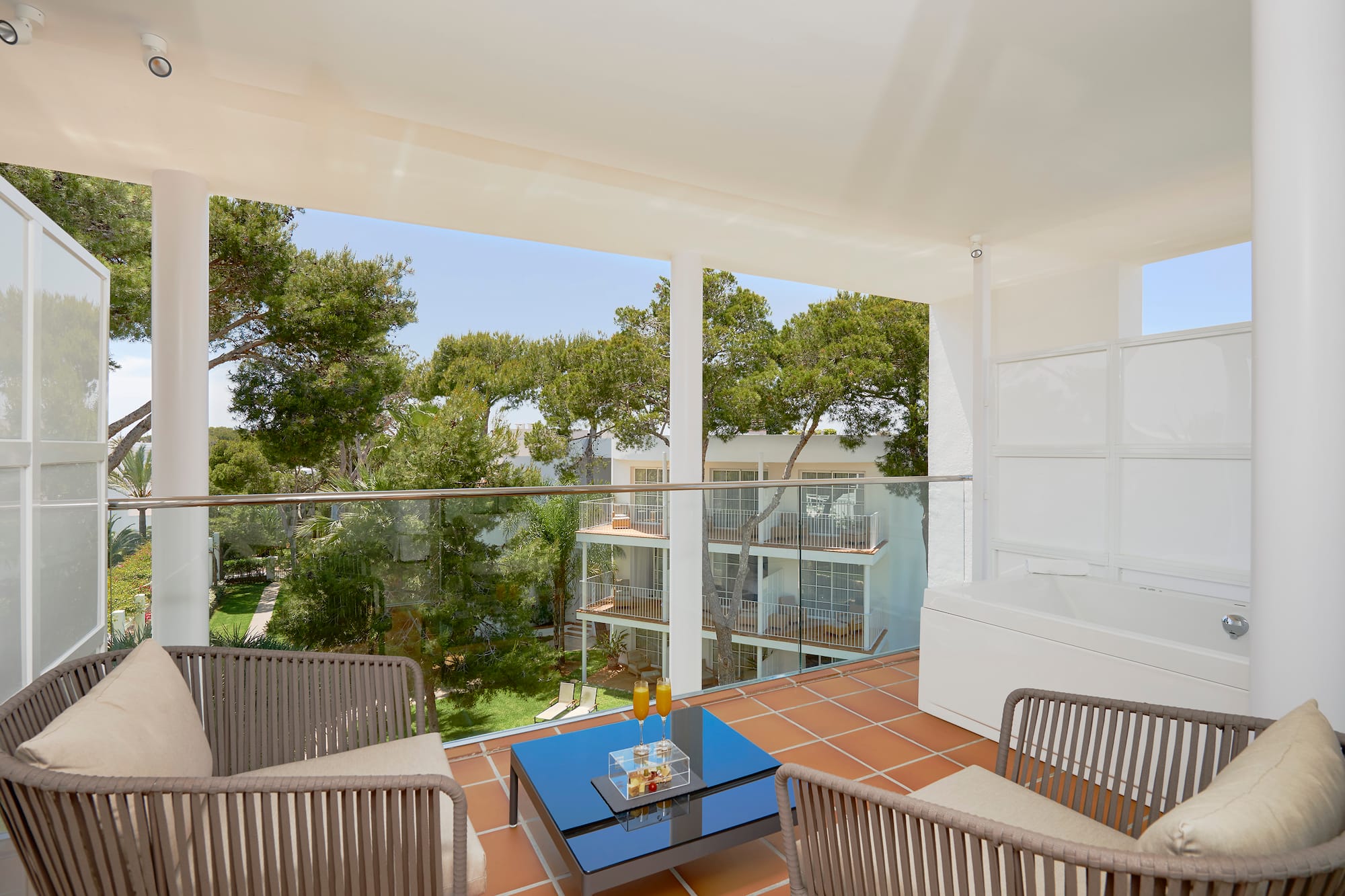 a balcony with a glass railing and chairs