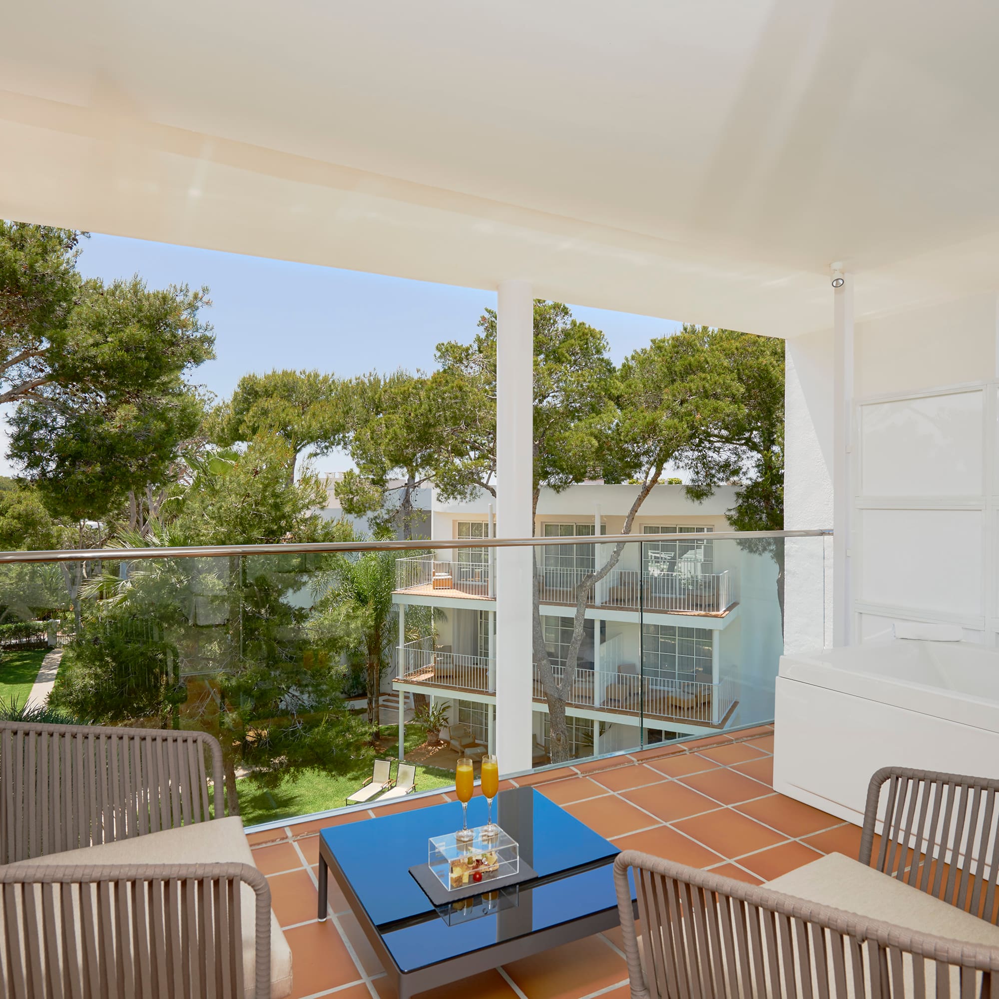 a balcony with a glass railing and chairs