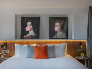 a bed with a couple of pictures of women blowing bubbles