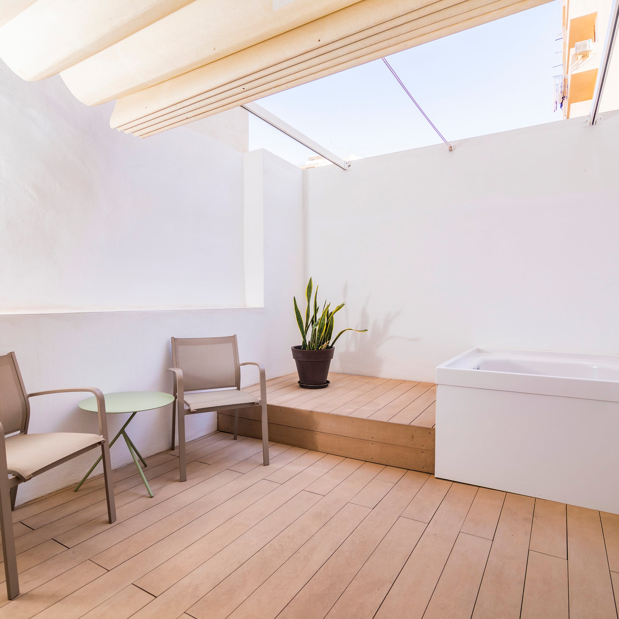 a patio with chairs and a bathtub