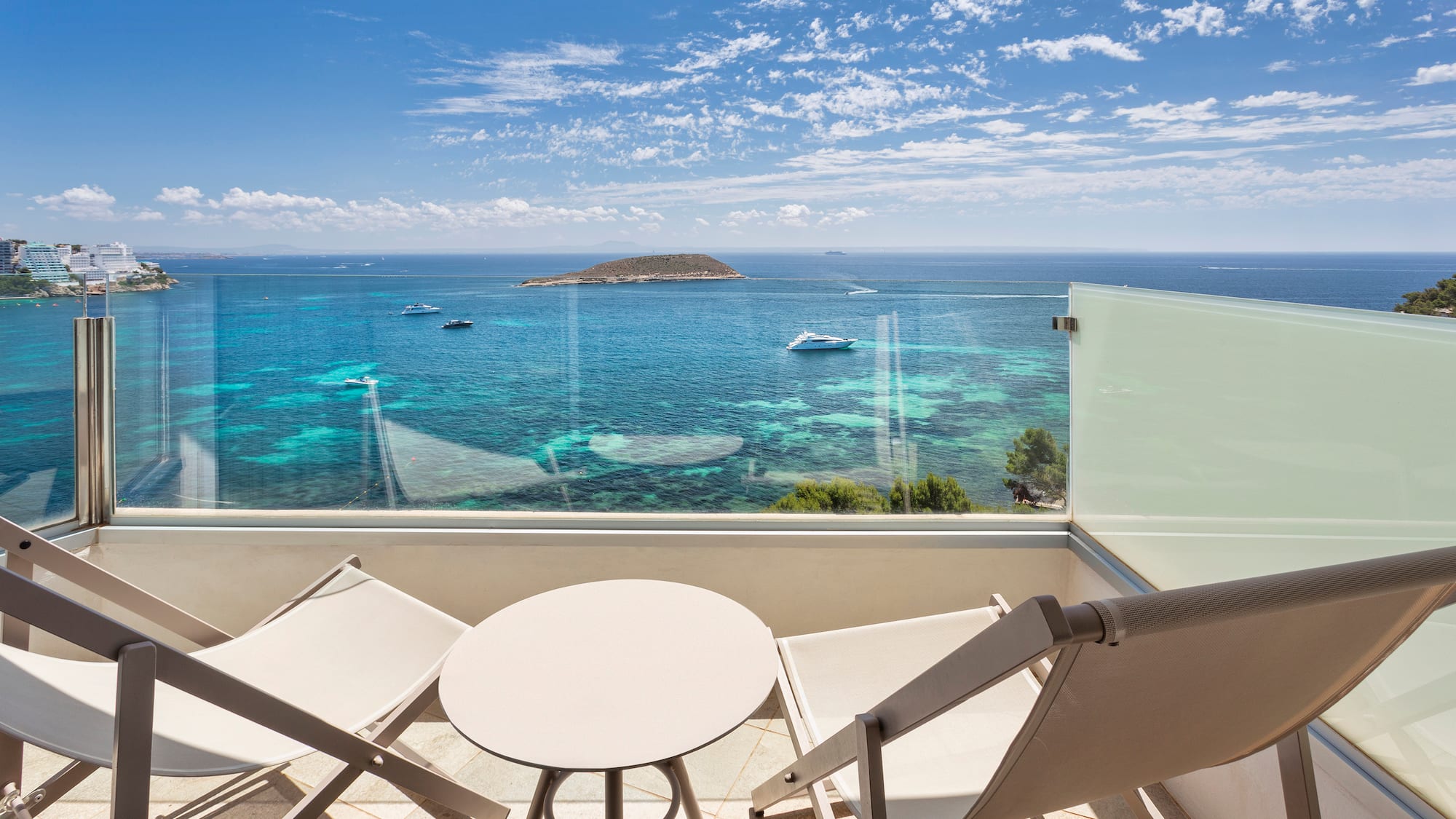 a deck with chairs and a table overlooking the ocean