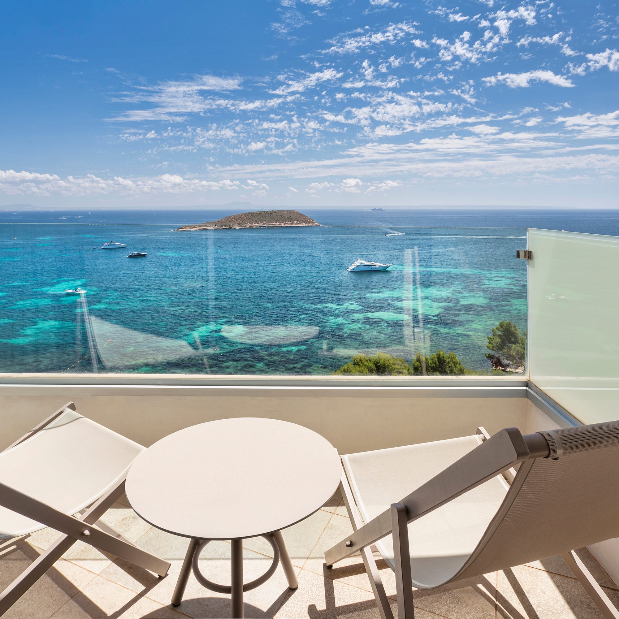a deck with chairs and a table overlooking the ocean