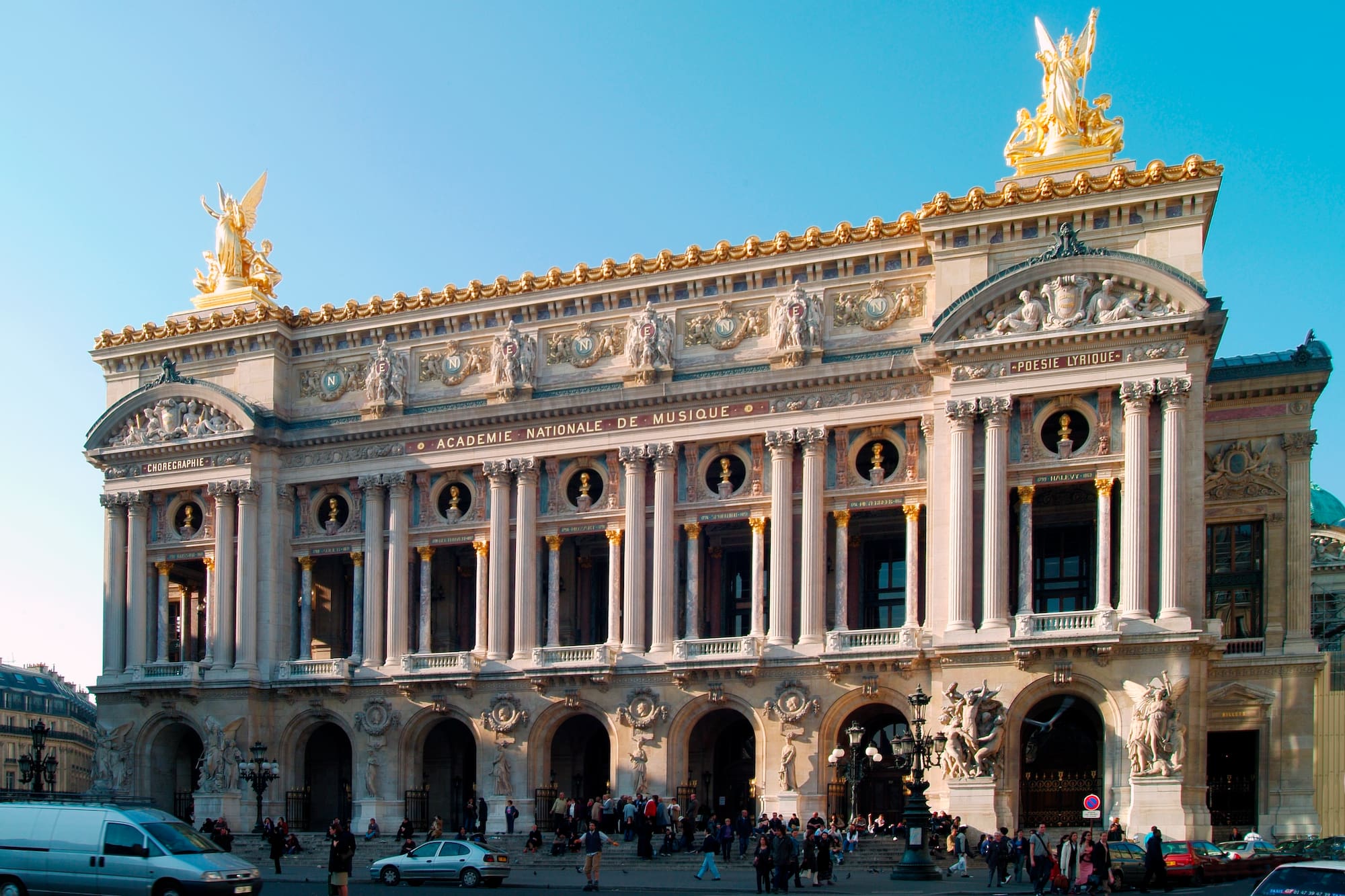 a large building with columns and statues with Palais Garnier in the background