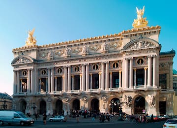 a large building with columns and statues with Palais Garnier in the background