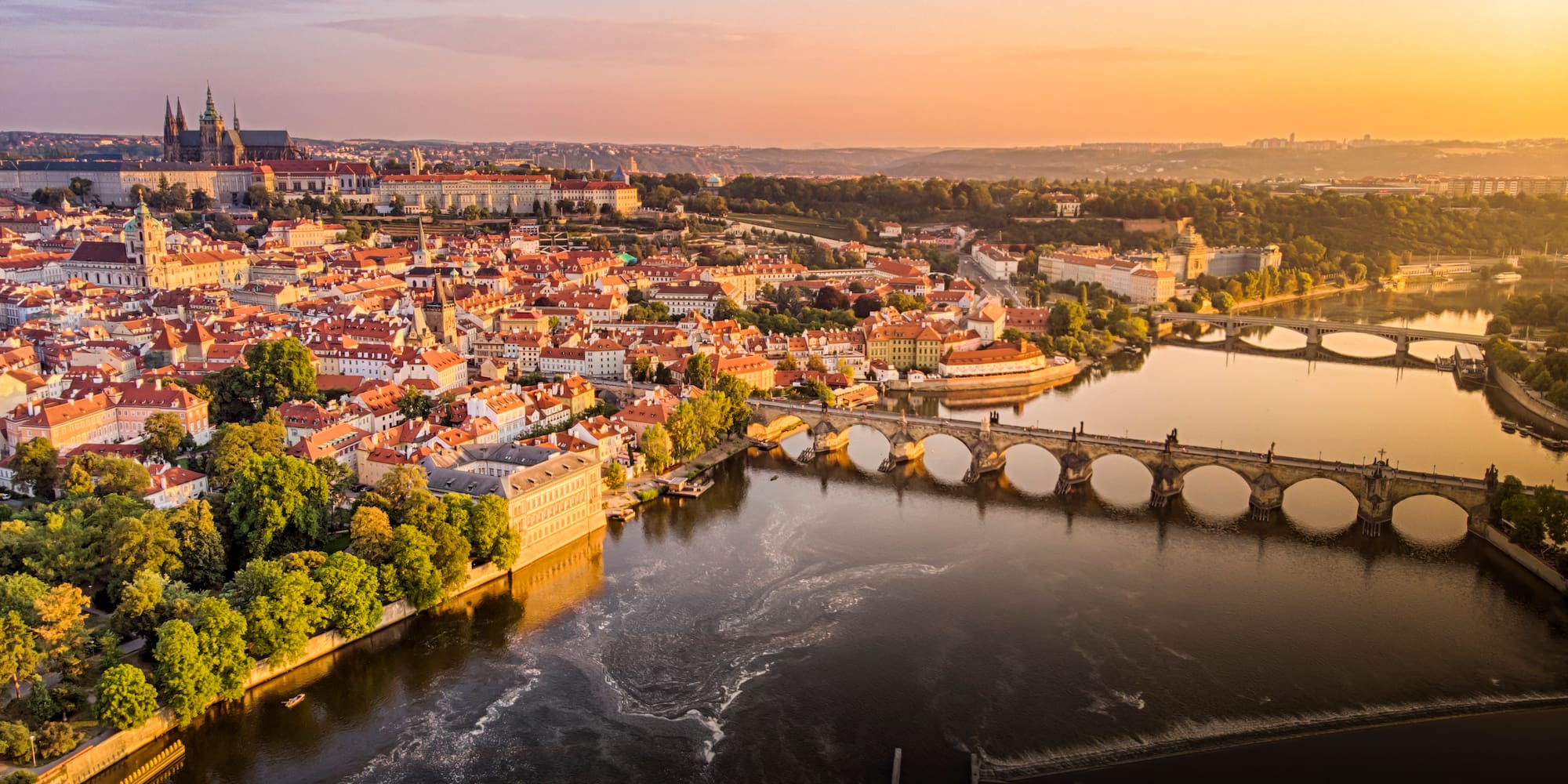 a bridge over a river with a city in the background