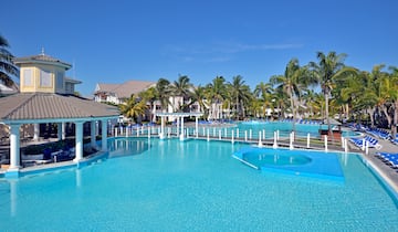 a swimming pool with palm trees and a building
