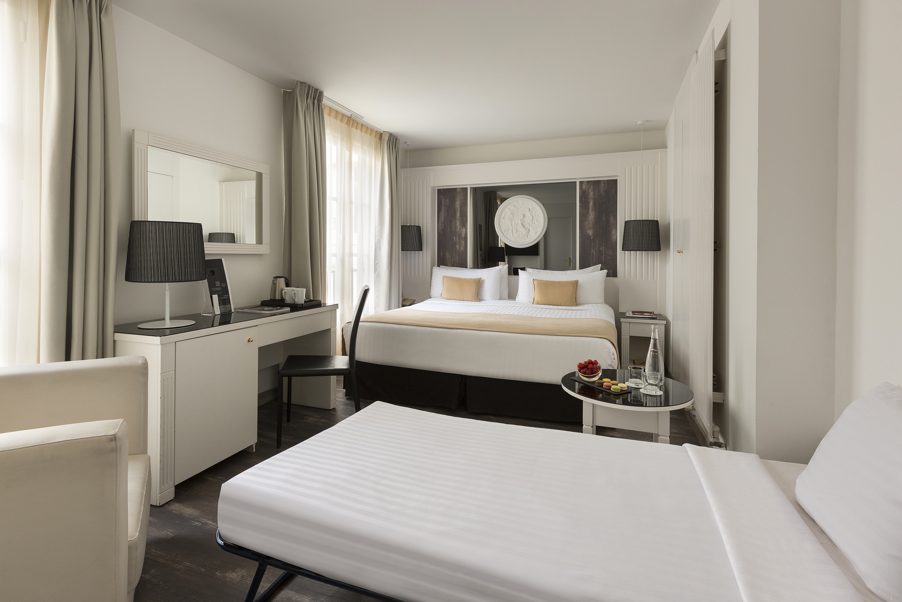 Contemporary hotel room featuring a double bed, sofa bed, and workspace.