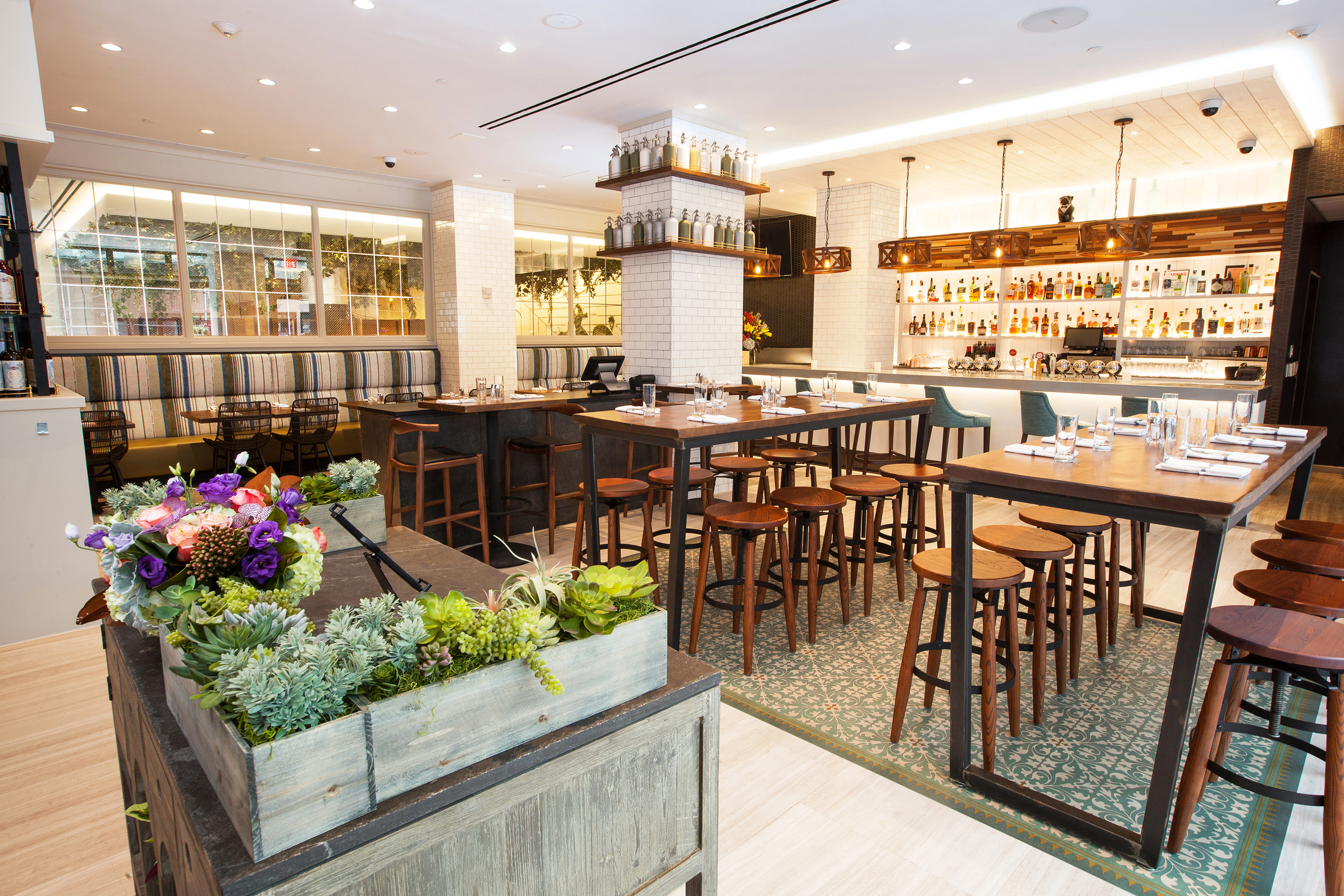 Modern restaurant bar and dining area with high-top tables and seating.