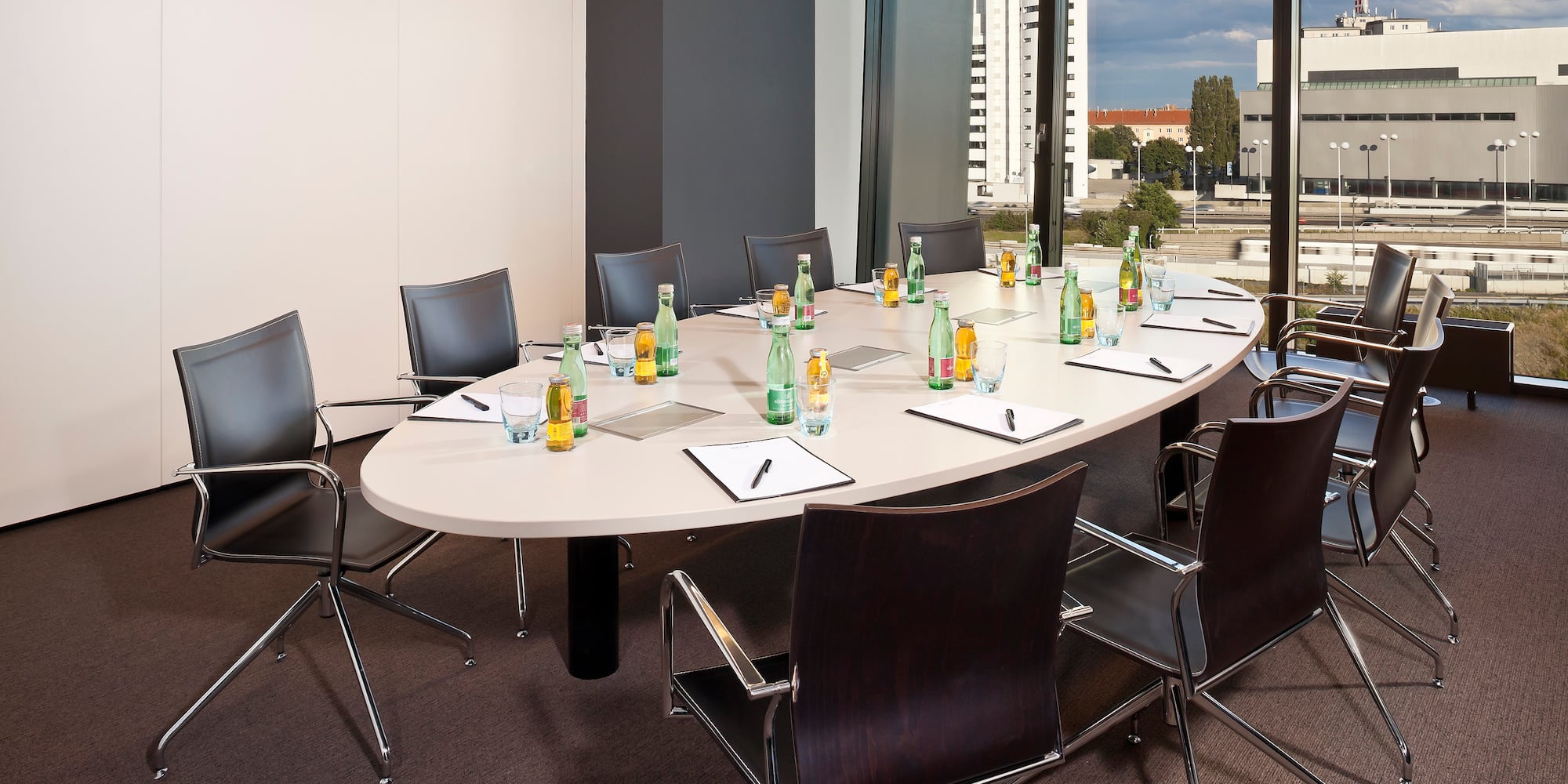 a conference room with a table with chairs and a few bottles of water