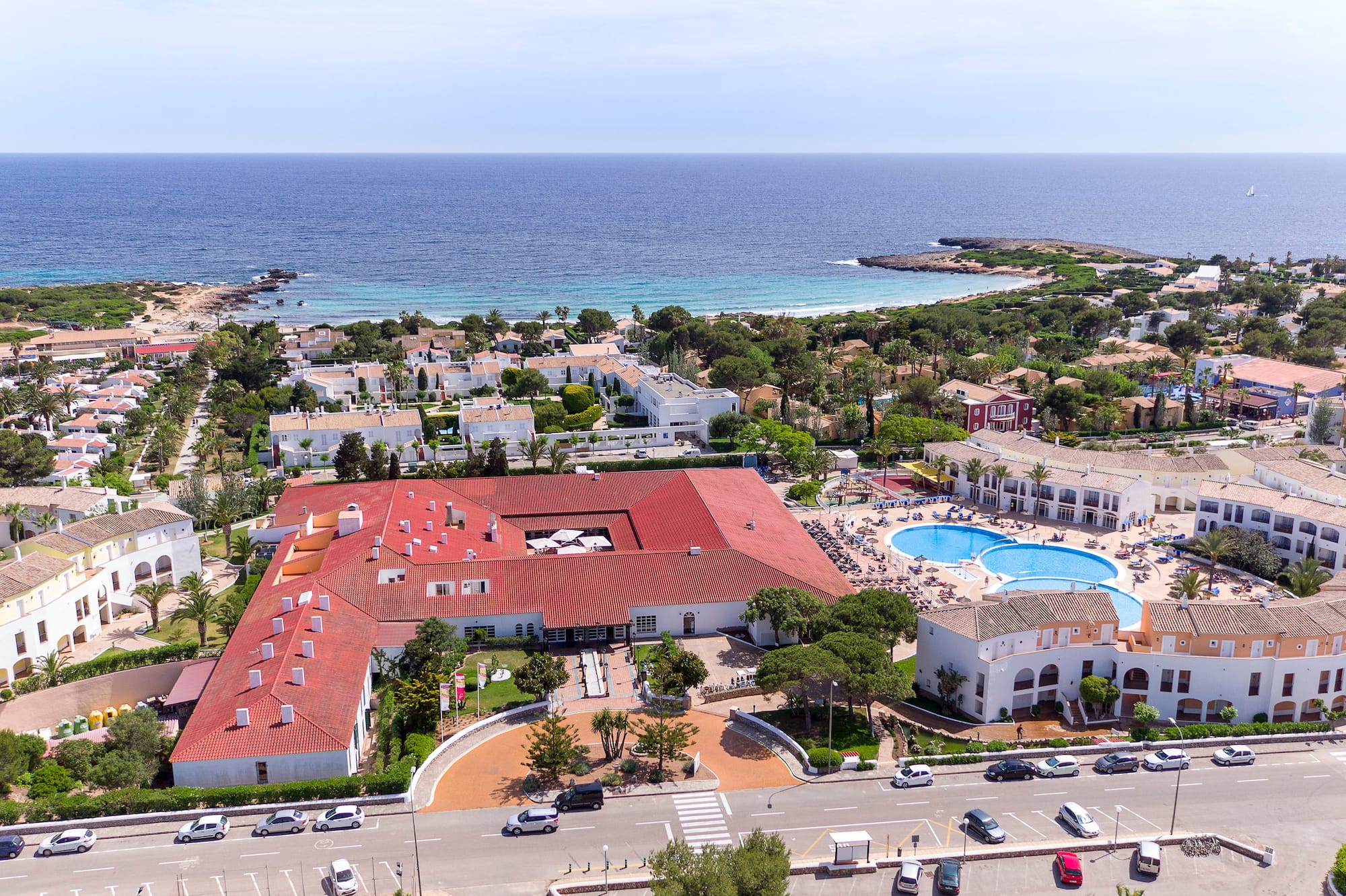 Aerial view of coastal resort with multiple swimming pools and ocean.