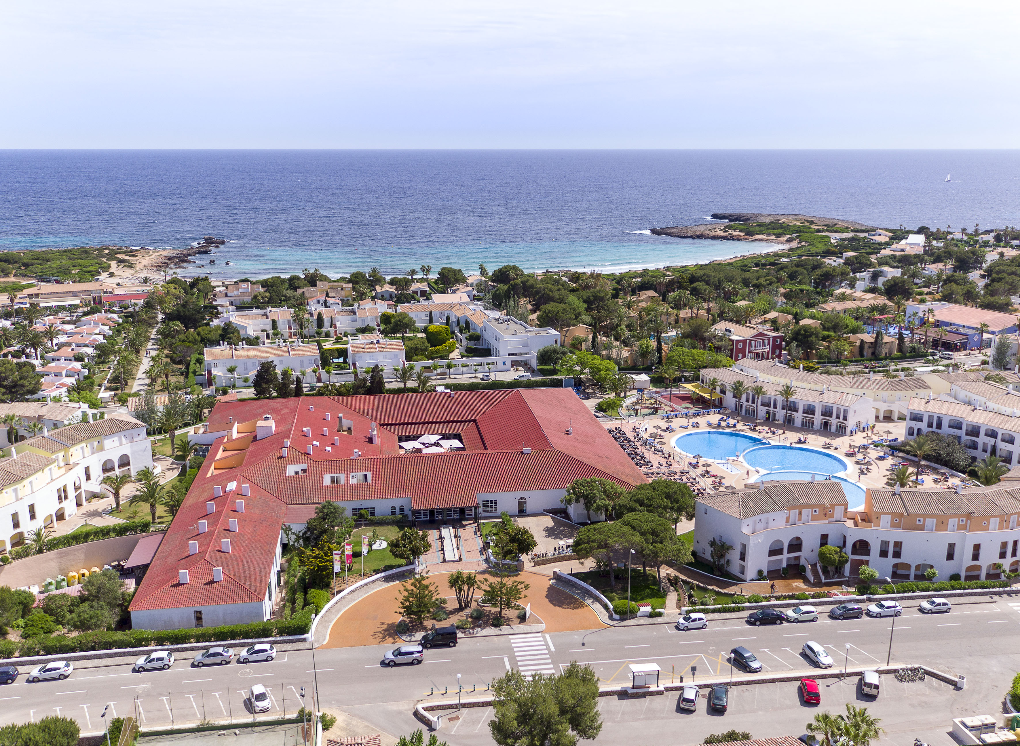 Aerial view of coastal resort with multiple swimming pools and ocean.