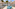 Luxury resort courtyard with palm trees, fountains, and blue sun loungers.