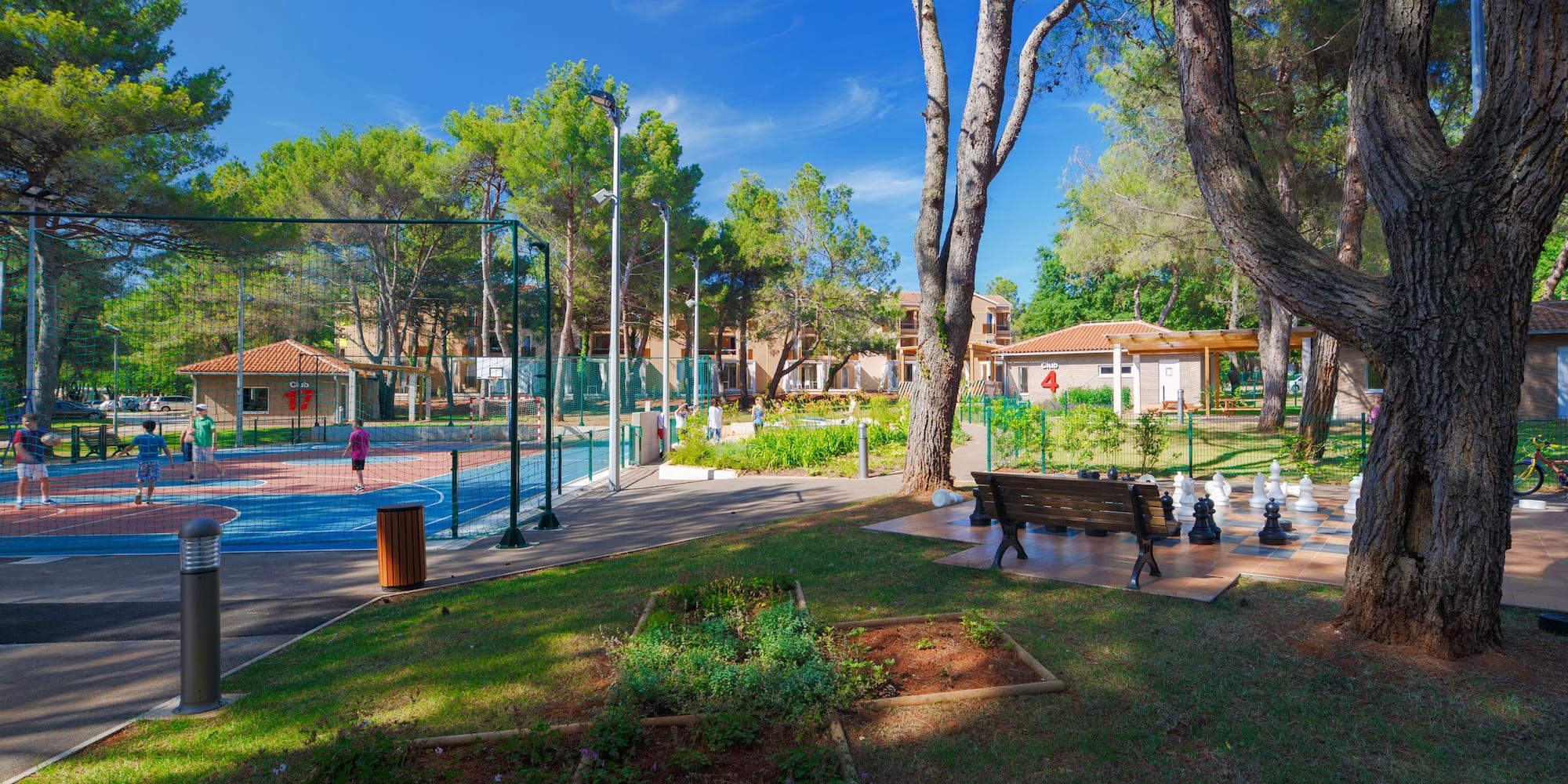 a park with a basketball court and a bench