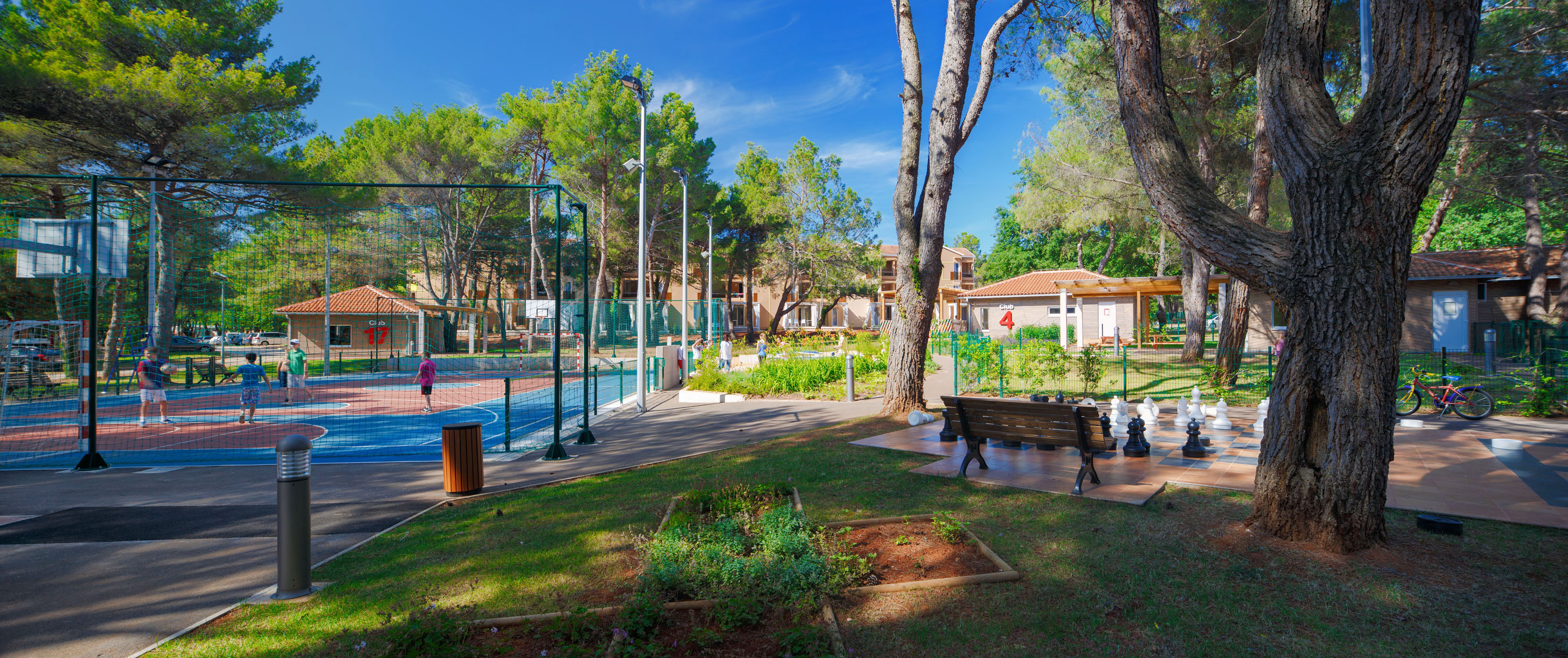 a park with a basketball court and a bench