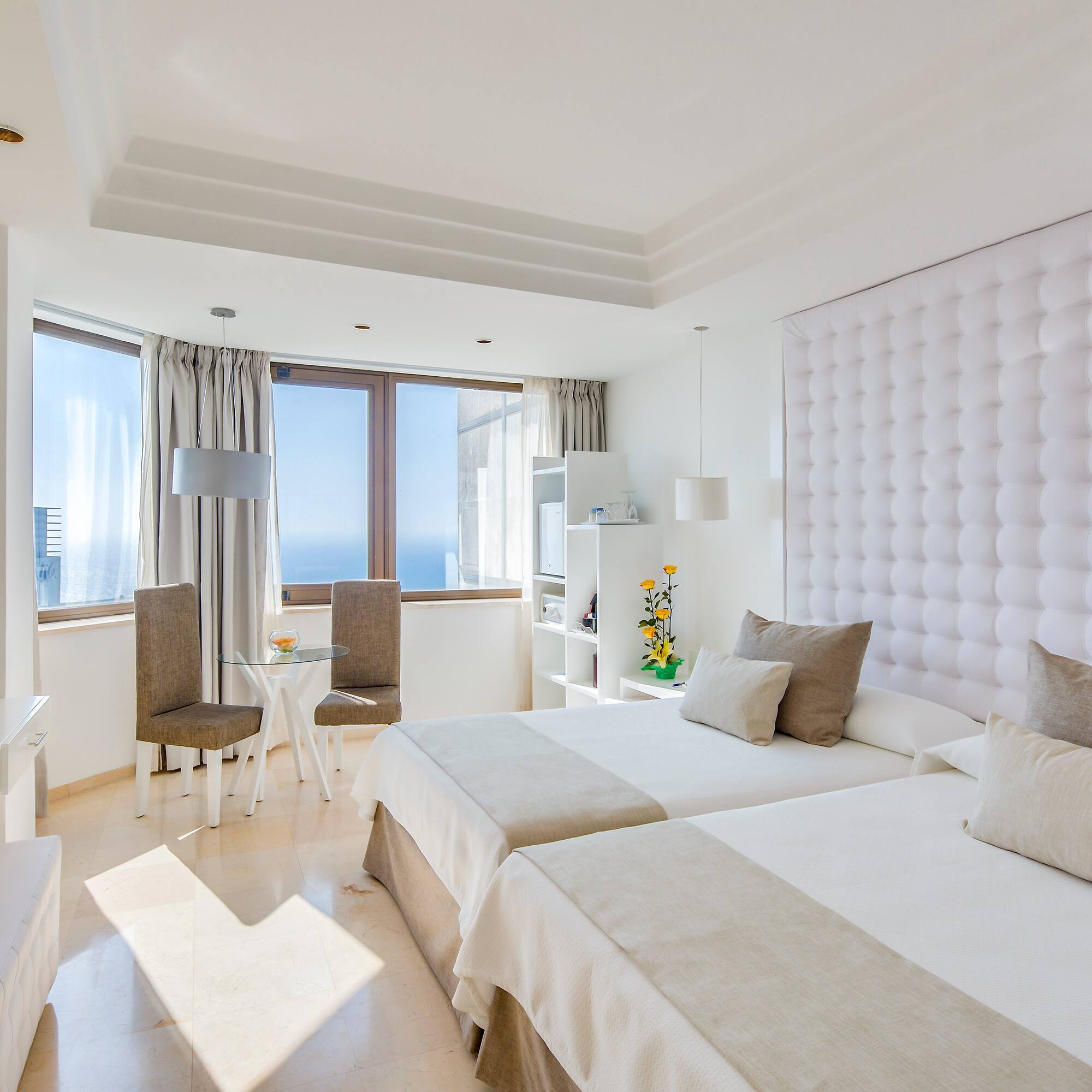 a room with two beds and a table and chairs