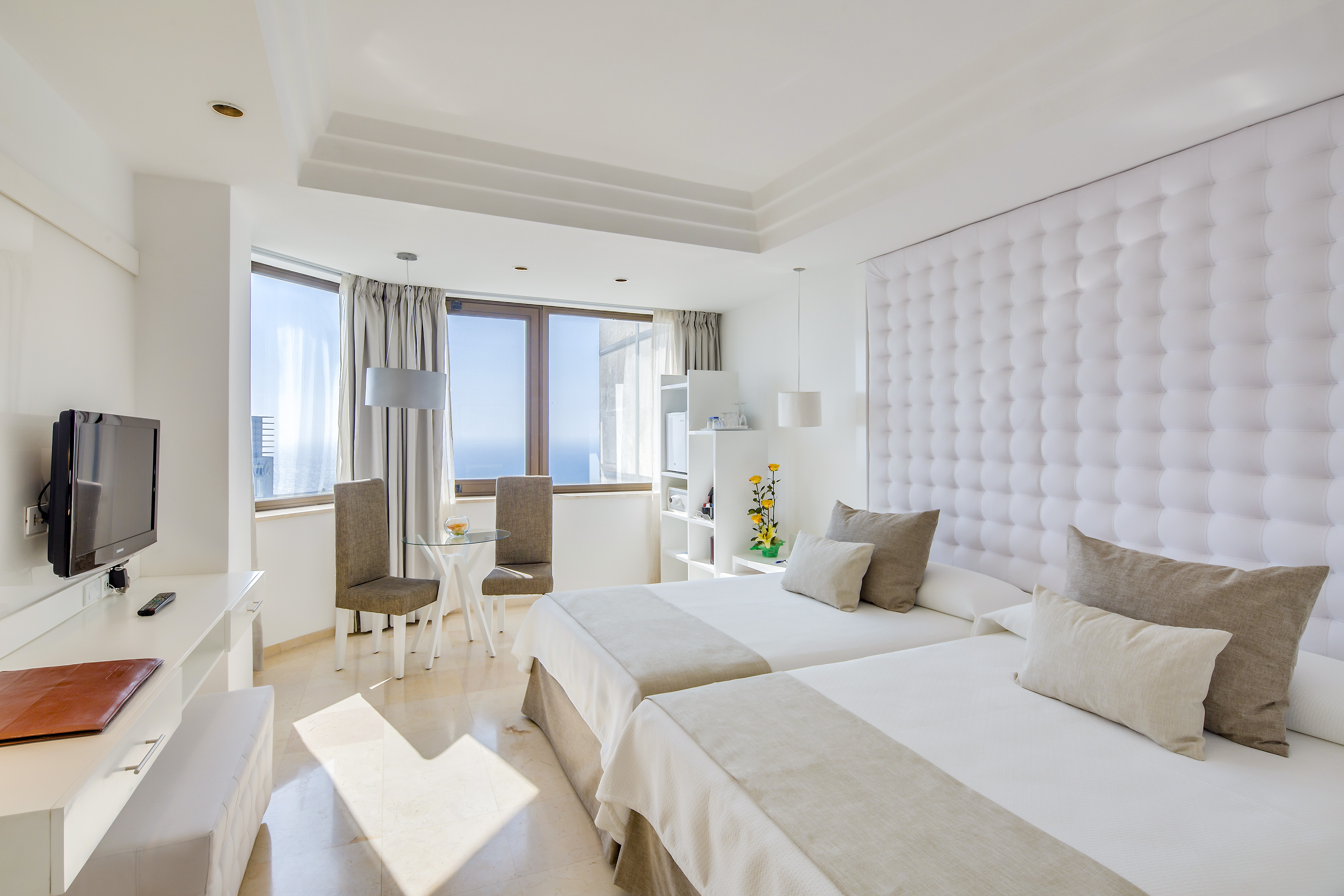 a room with two beds and a table and chairs