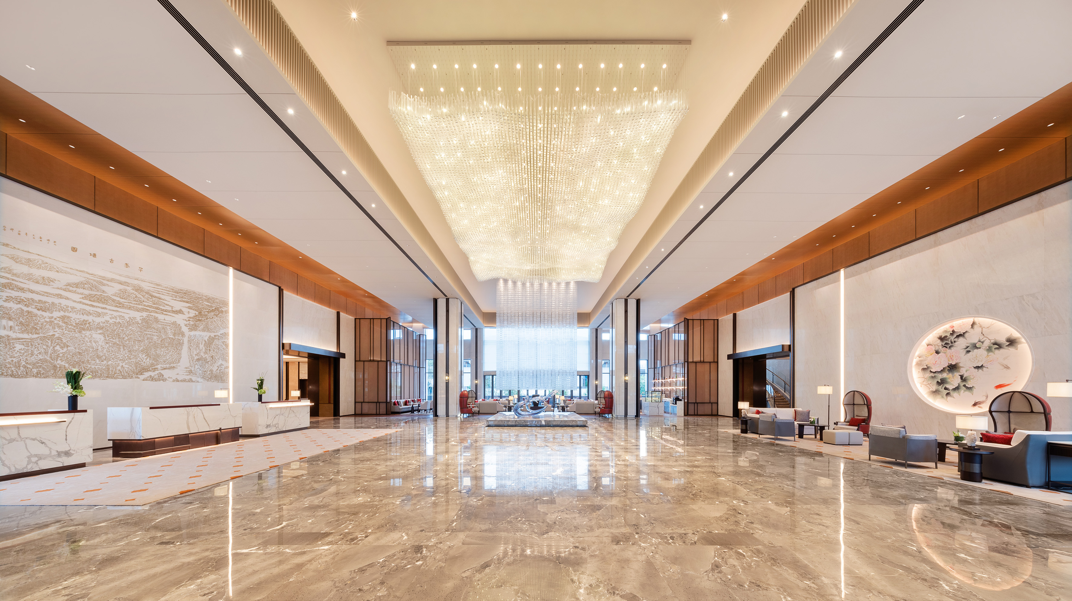 Luxurious hotel reception with grand chandelier, polished marble, modern design.