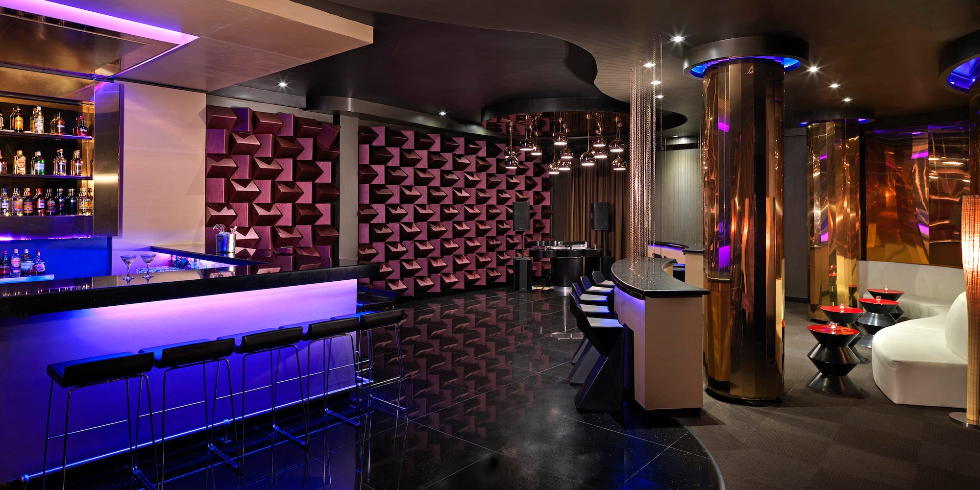 a room with a bar and purple lights