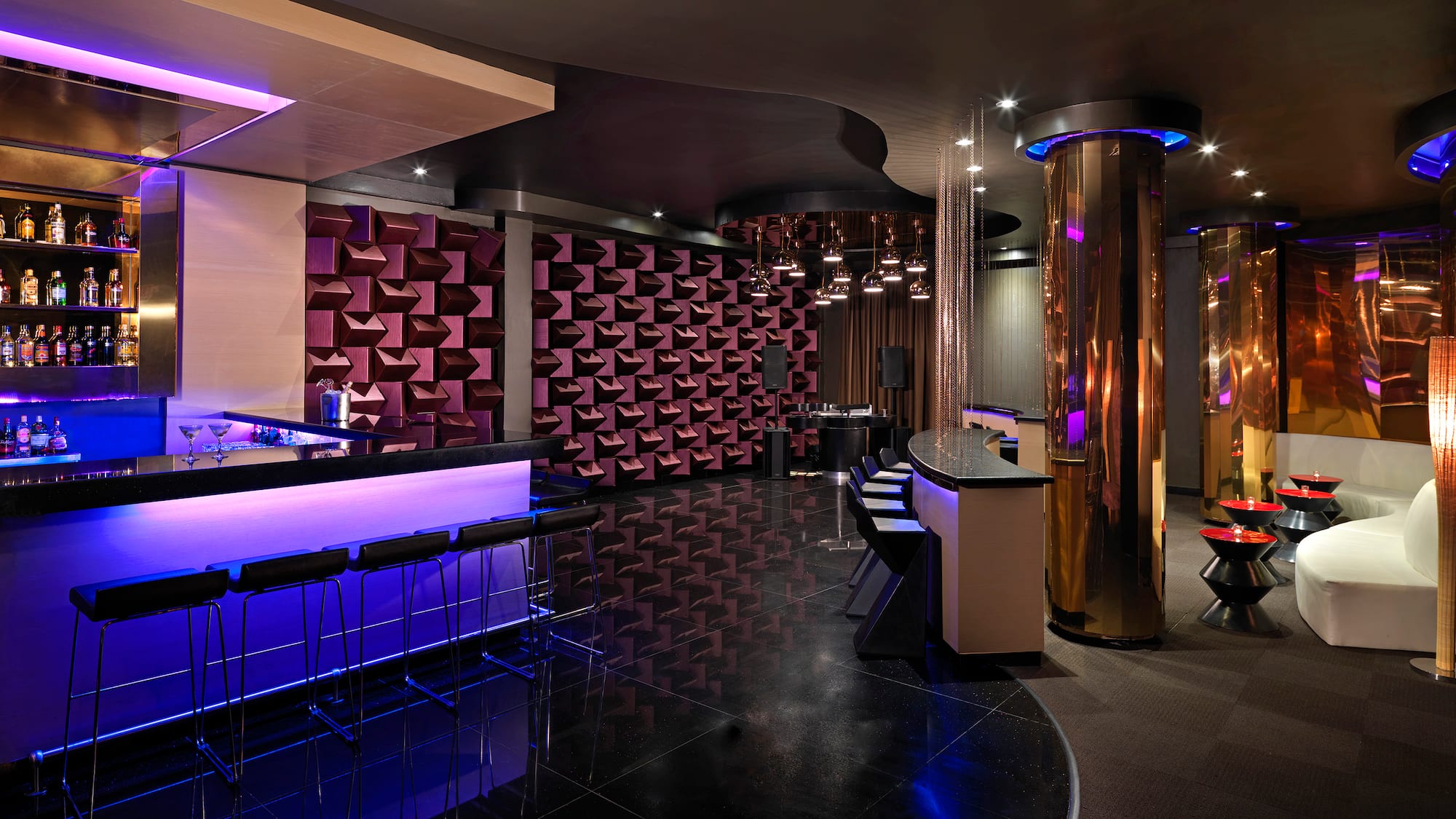 a room with a bar and purple lights