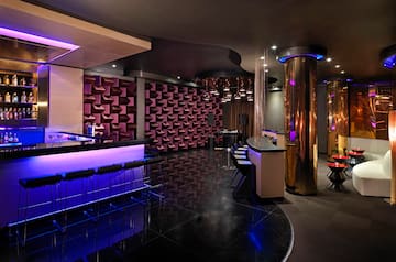 a room with a bar and purple lights