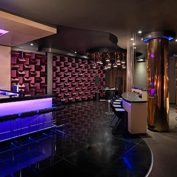 a room with a bar and purple lights