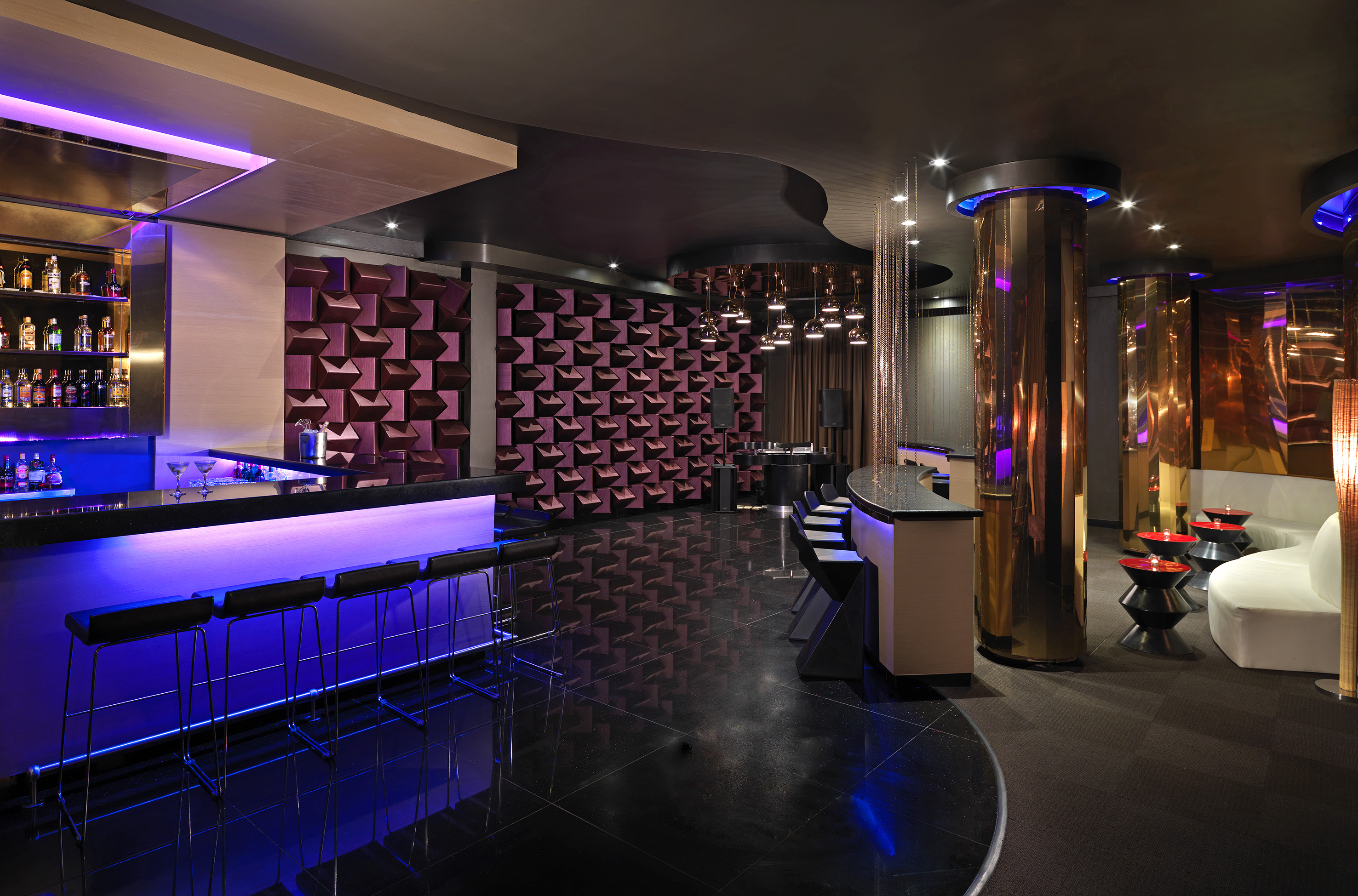 a room with a bar and purple lights
