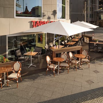a patio with tables and chairs outside of a building
