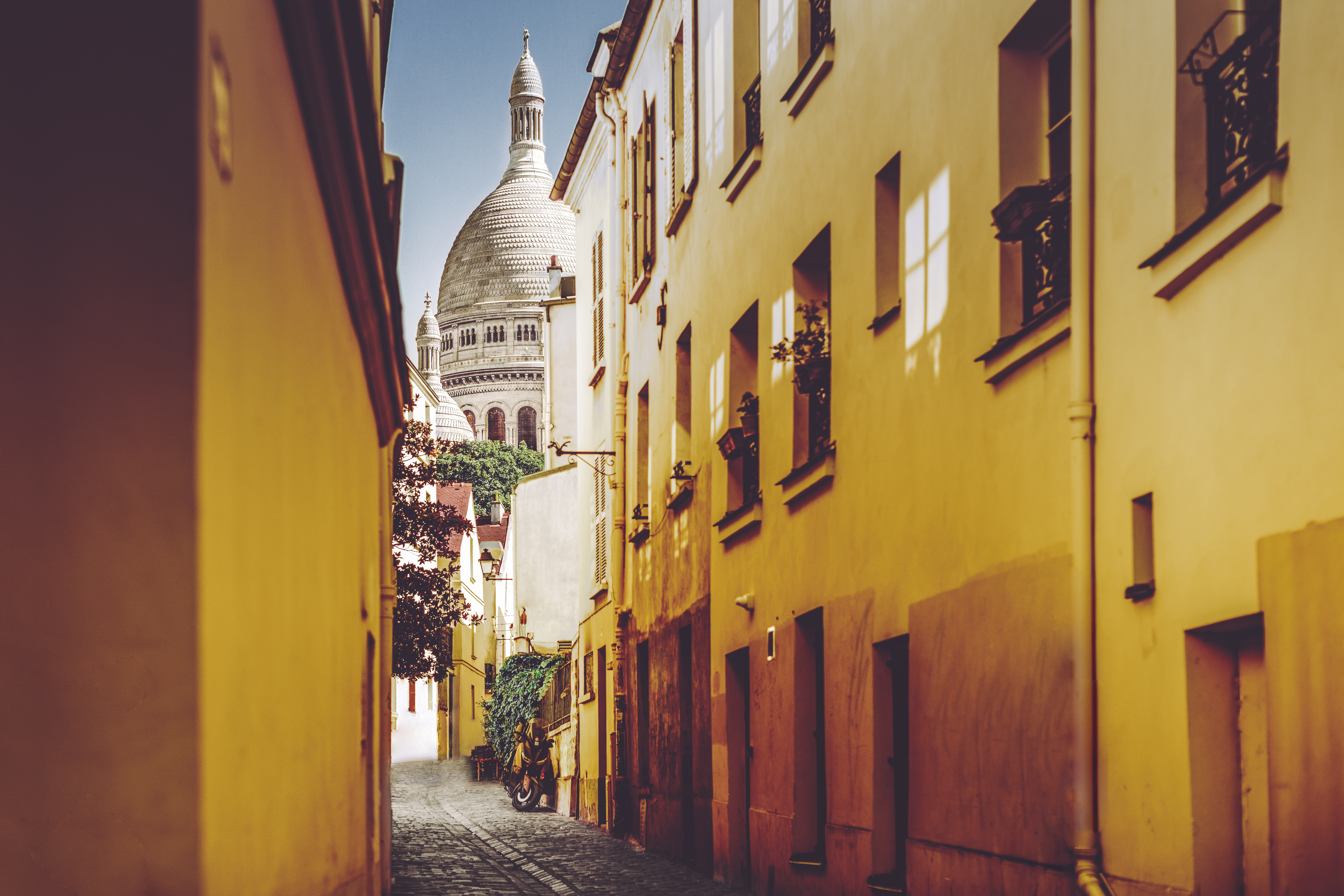 a narrow street with a building in the background