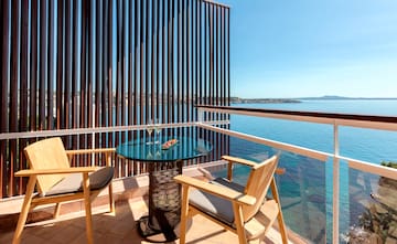 a table and chairs on a balcony overlooking the water