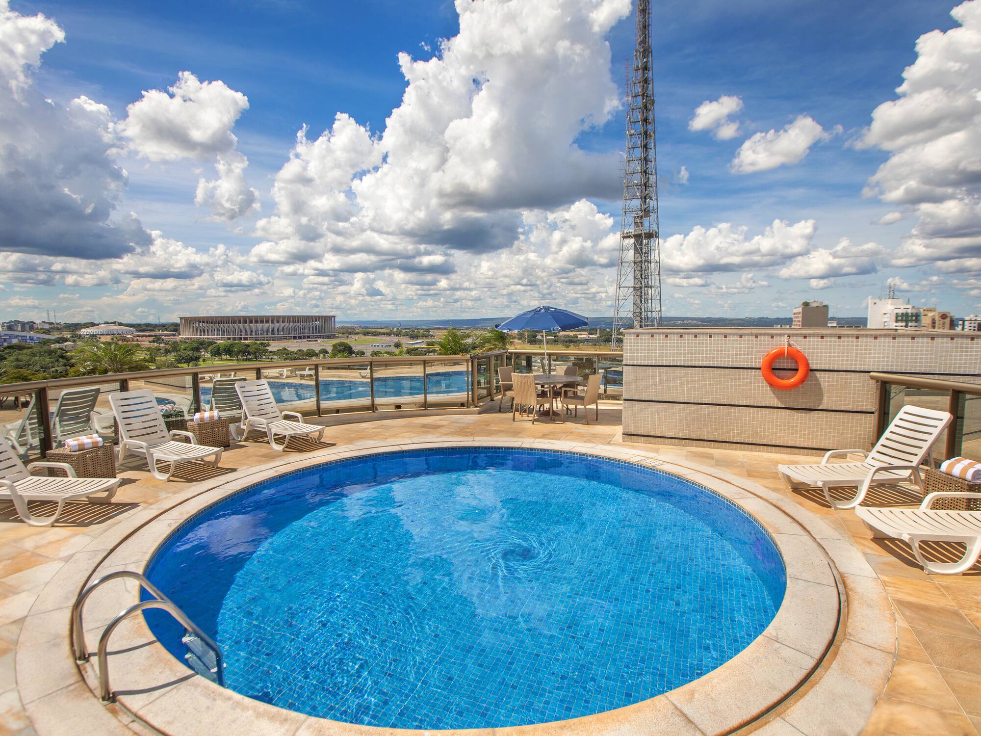 a pool with chairs and a tower on the side