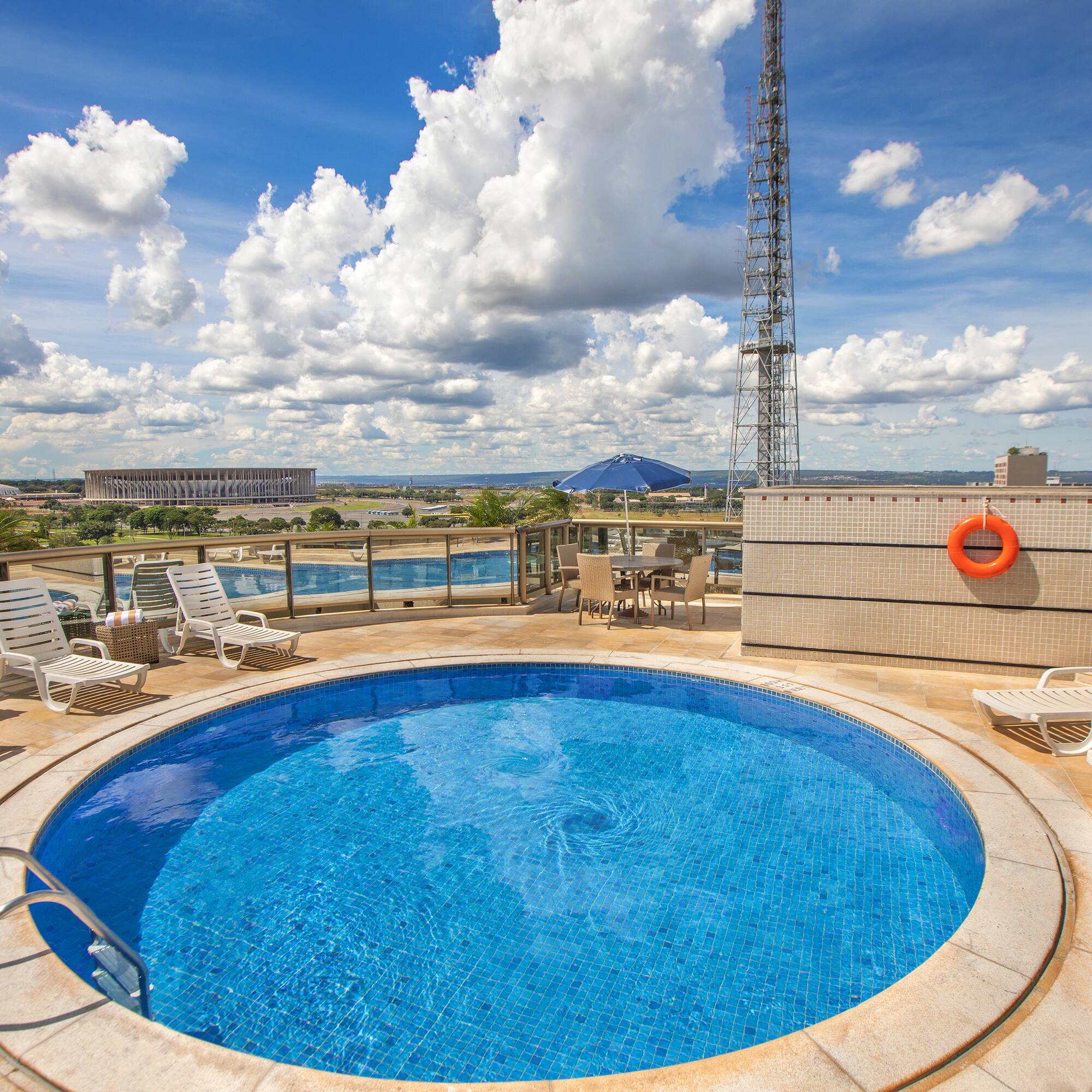 a pool with chairs and a tower on the side